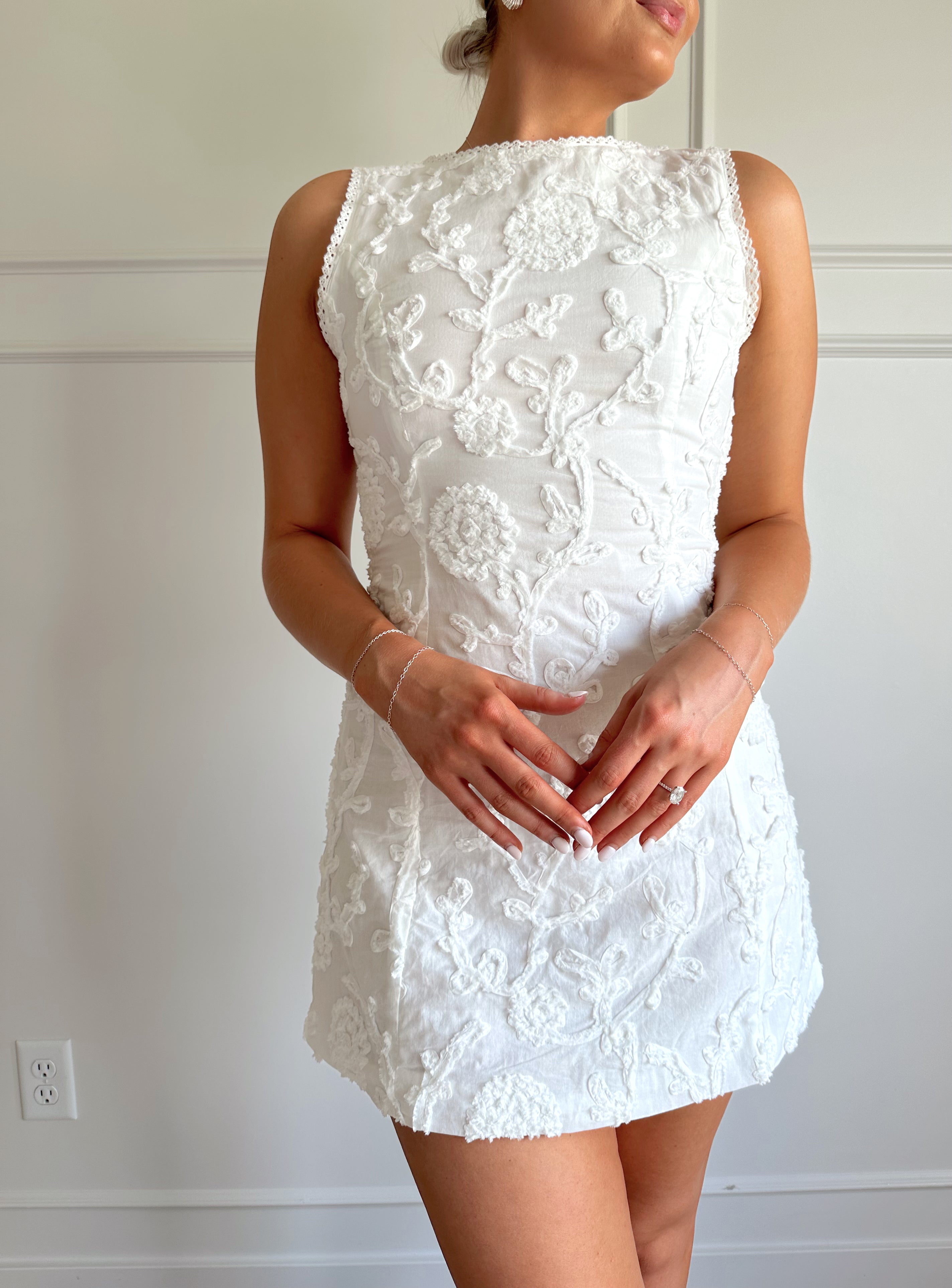 White a-line mini dress with floral jacquard pattern.