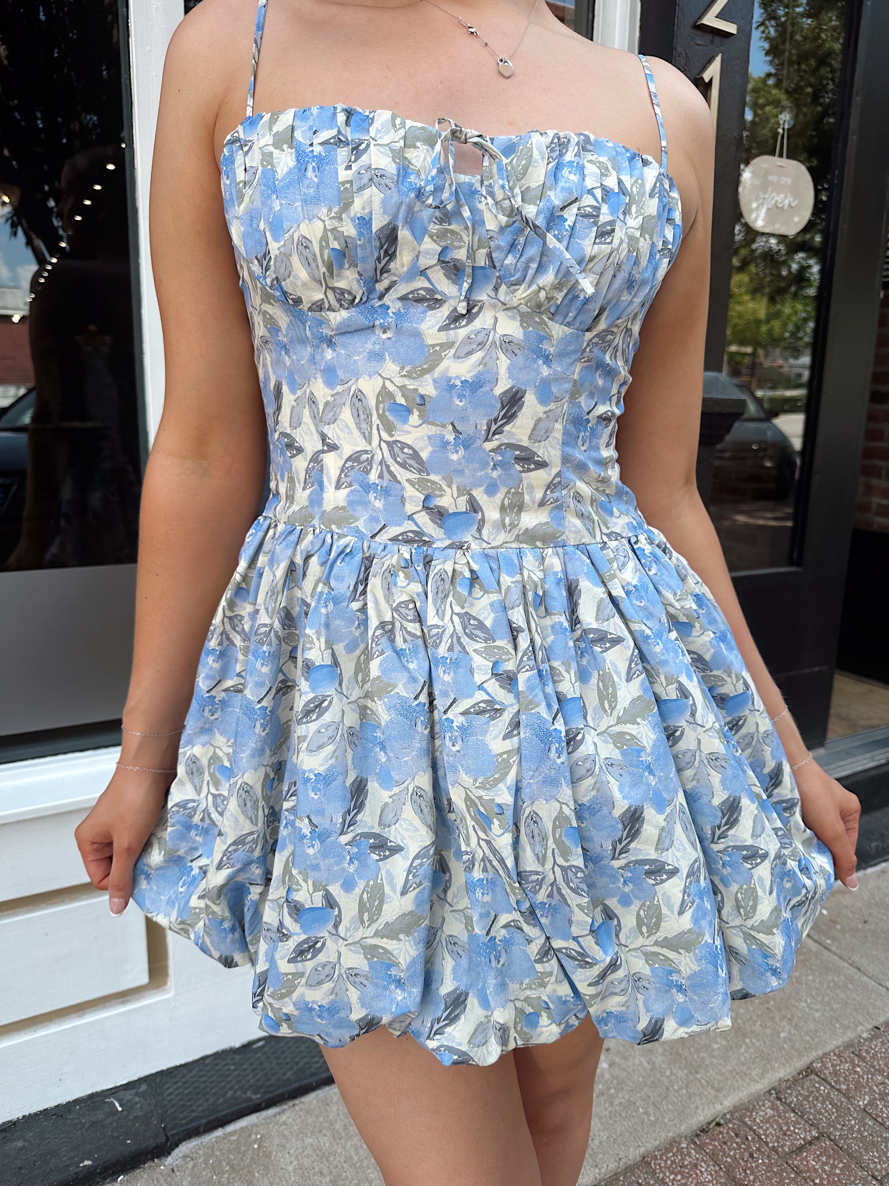 Blue floral bustier mini dress with bubble hem and tie detail.