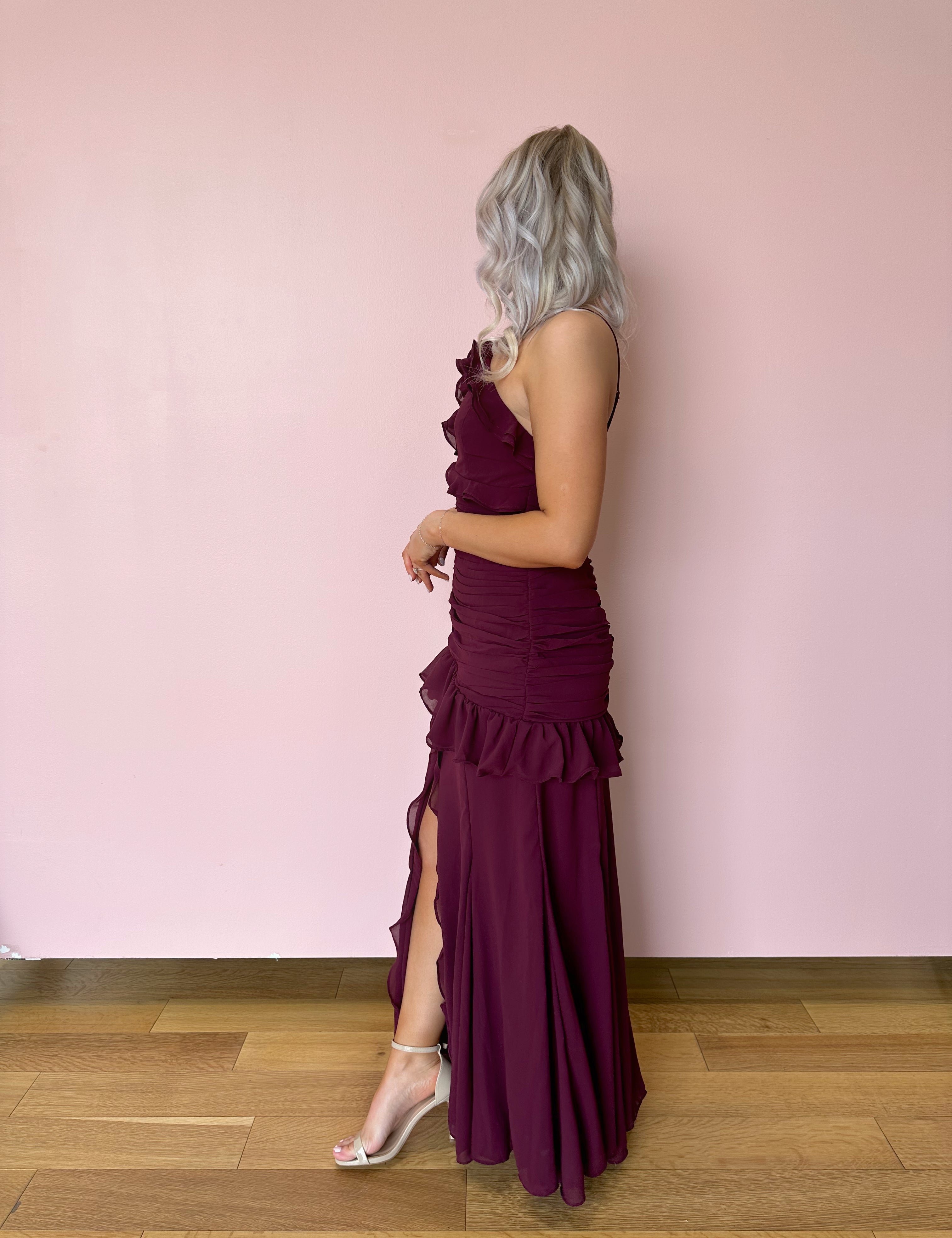 Burgundy formal maxi dress with ruffle detailing and slit up the front. 