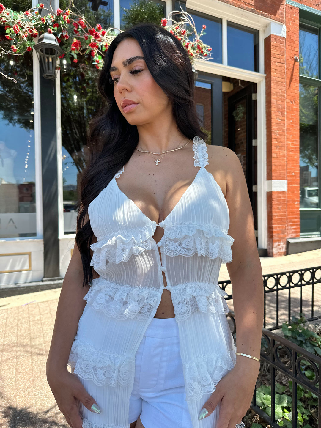 Woman wearing white sheer overlay duster with ruffle tiered detailing, and button closure.