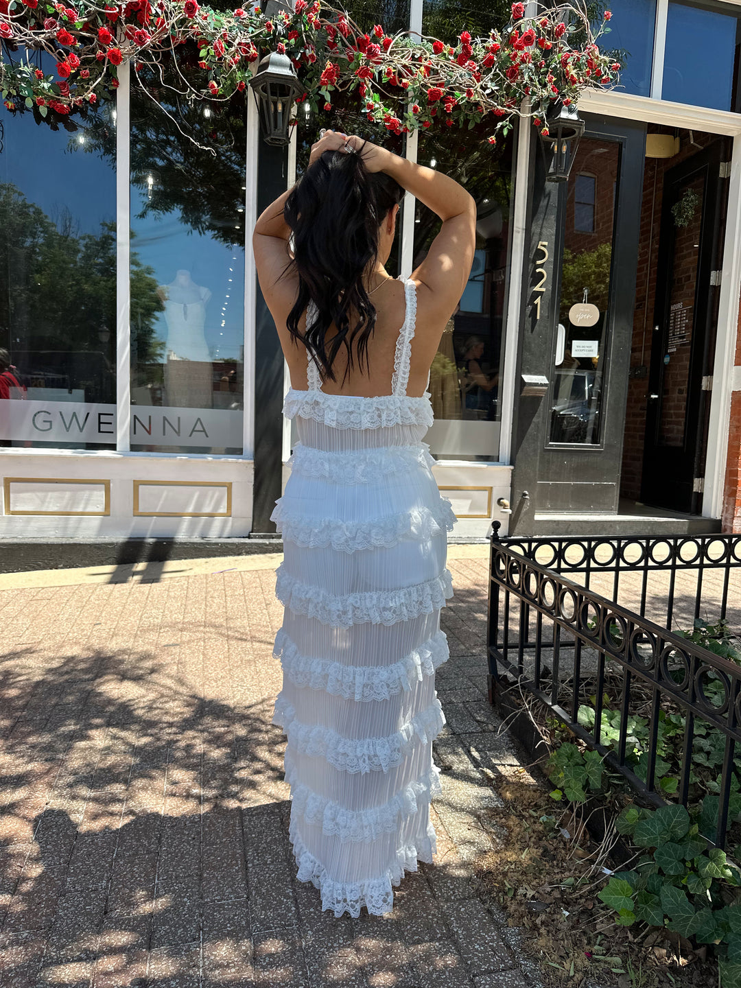 Woman wearing white sheer overlay duster with ruffle tiered detailing, and button closure.