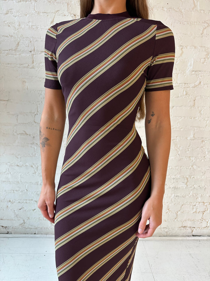 Woman wearing multi stripe maxi dress with short sleeves, and keyhole cutout on the back. 