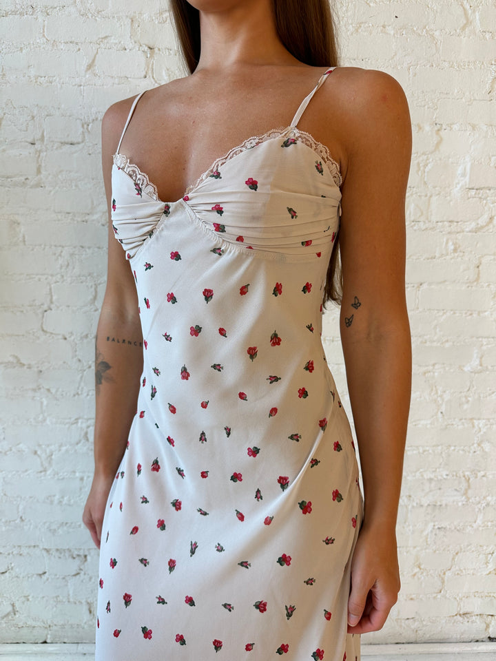 Woman wearing taupe midi dress with red floral with lace trim detailing. 