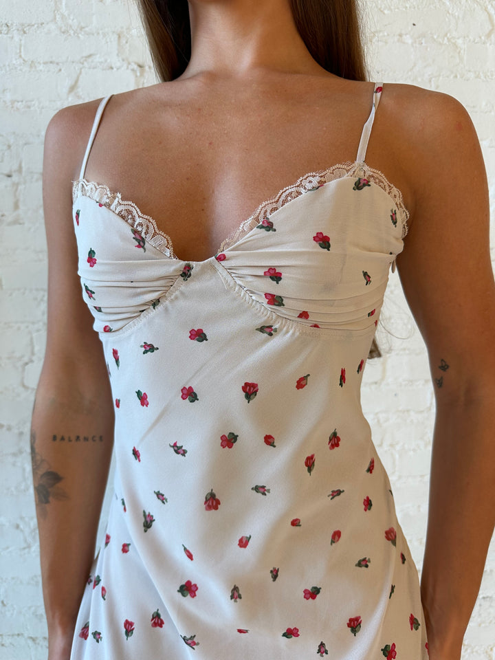 Woman wearing taupe midi dress with red floral with lace trim detailing. 