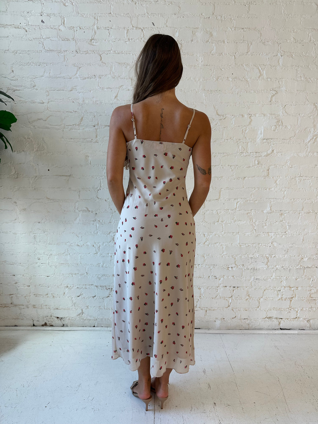 Woman wearing taupe midi dress with red floral with lace trim detailing. 