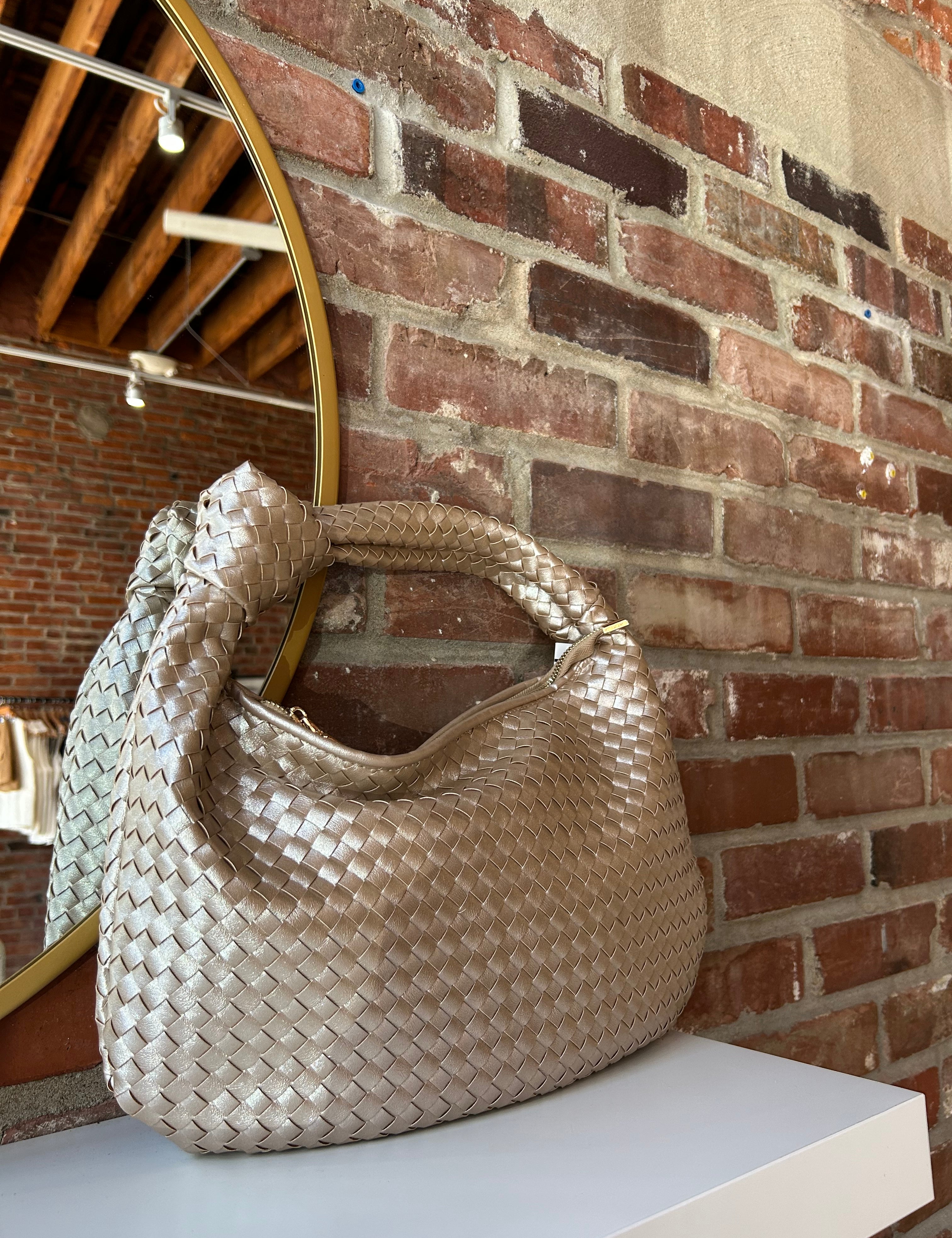 Champagne color woven shoulder bag with gold hardware and knits detail. 