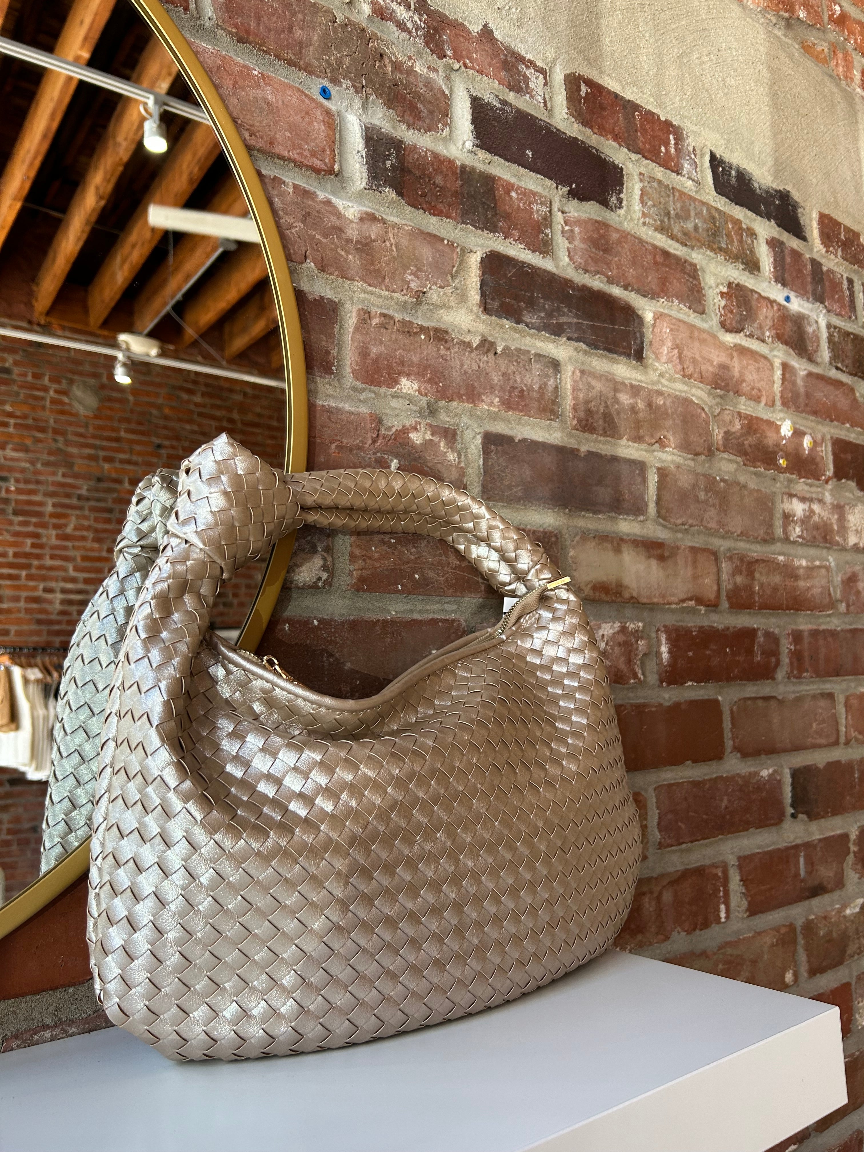 Champagne color woven shoulder bag with gold hardware and knits detail. 
