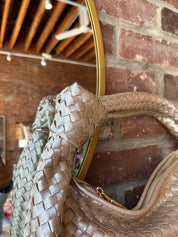 Champagne color woven shoulder bag with gold hardware and knits detail. 