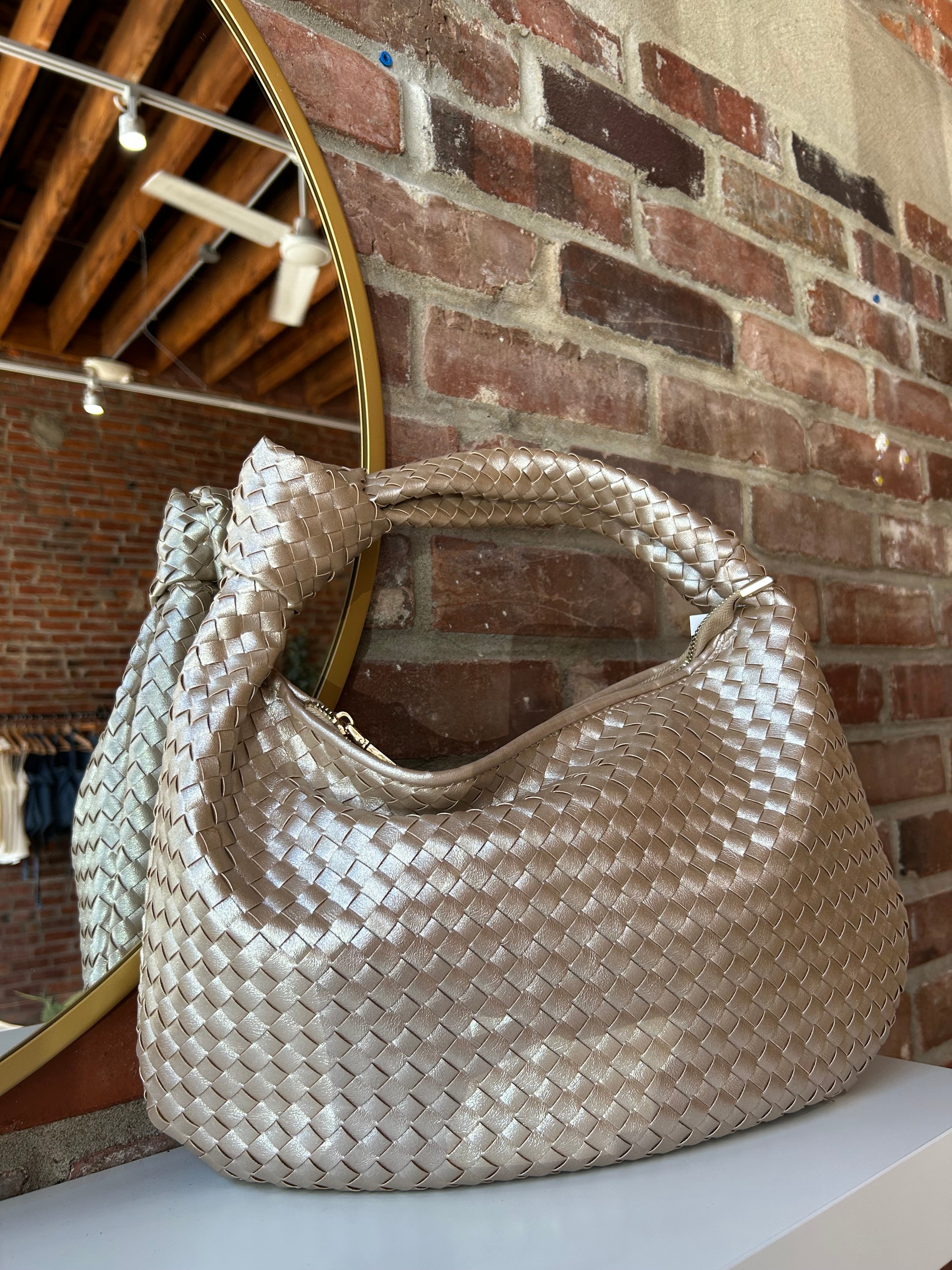 Champagne color woven shoulder bag with gold hardware and knits detail. 