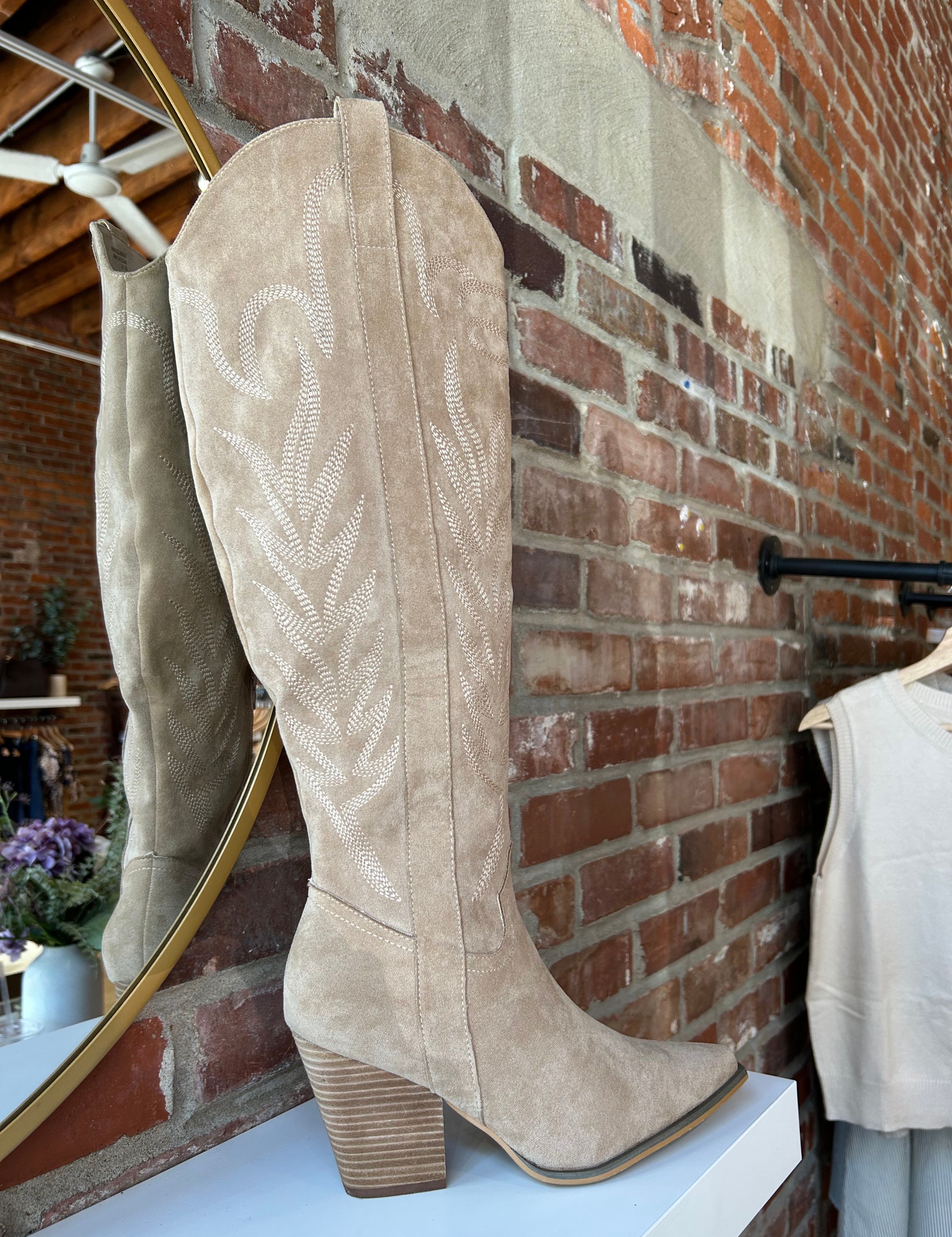 Tan suede tall Western boot with embroidered stitching, pointed toe, and stacked block heel
