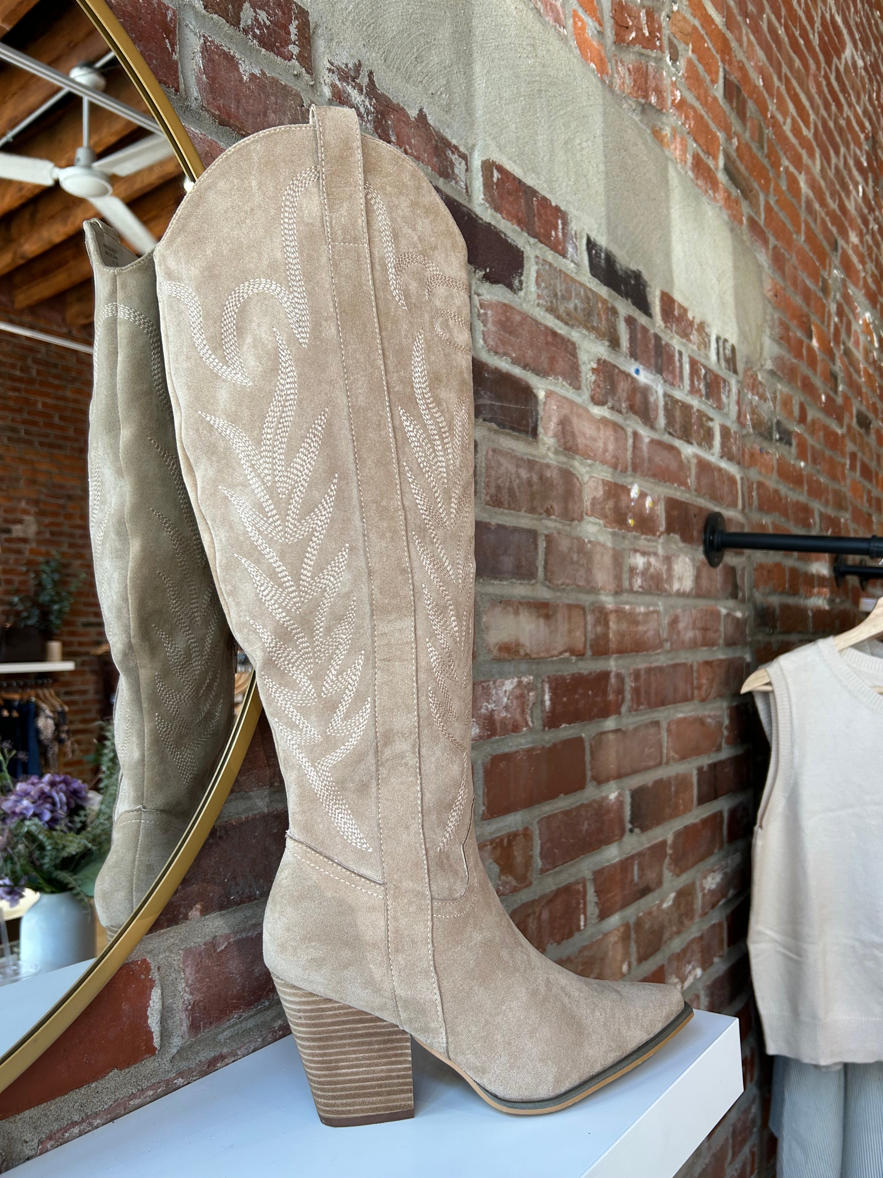 Tan suede tall Western boot with embroidered stitching, pointed toe, and stacked block heel
