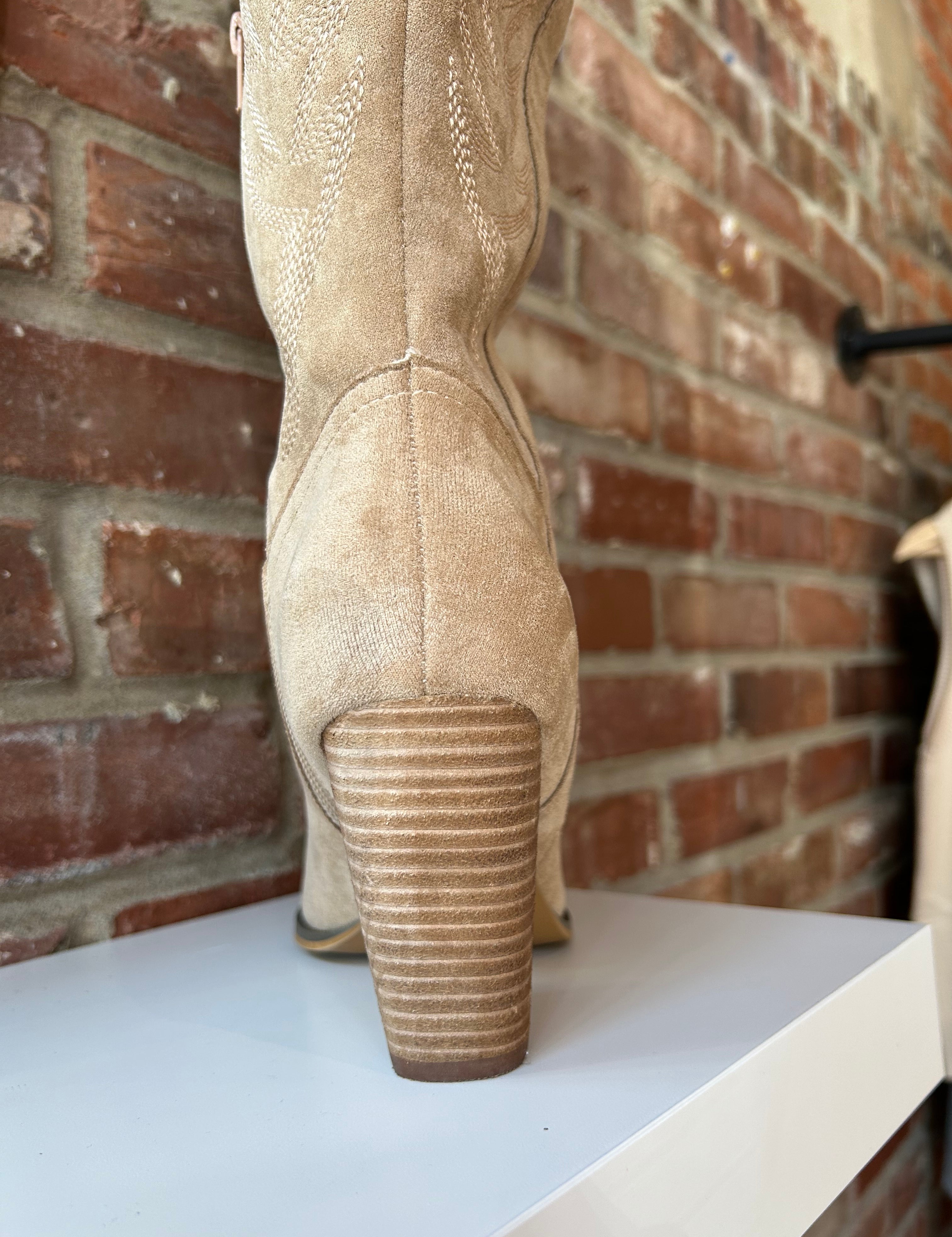 Tan suede tall Western boot with embroidered stitching, pointed toe, and stacked block heel
