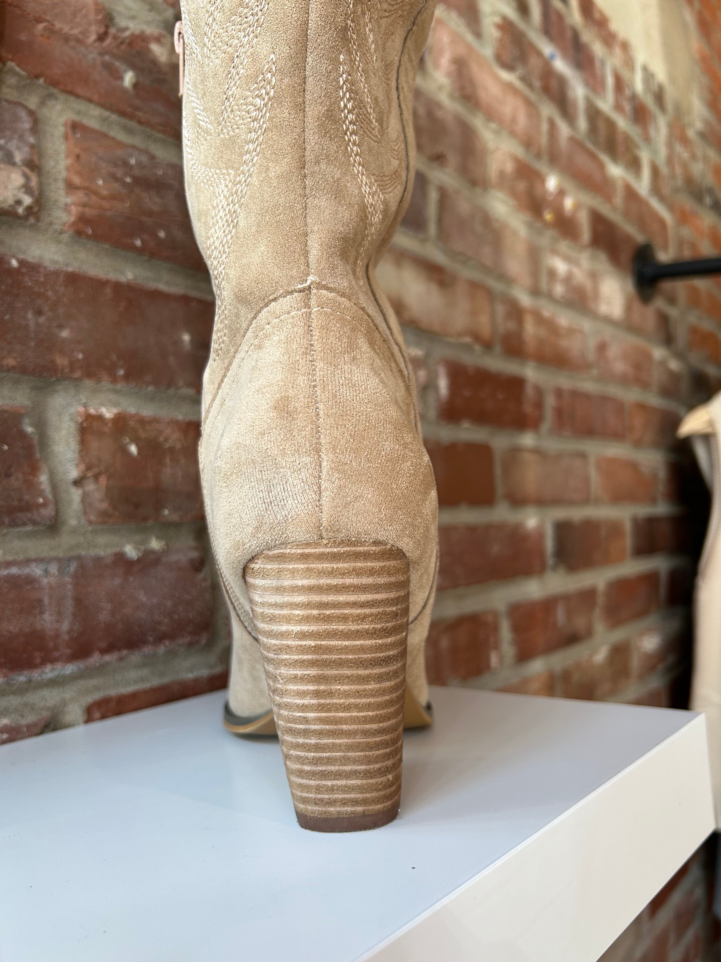 Tan suede tall Western boot with embroidered stitching, pointed toe, and stacked block heel
