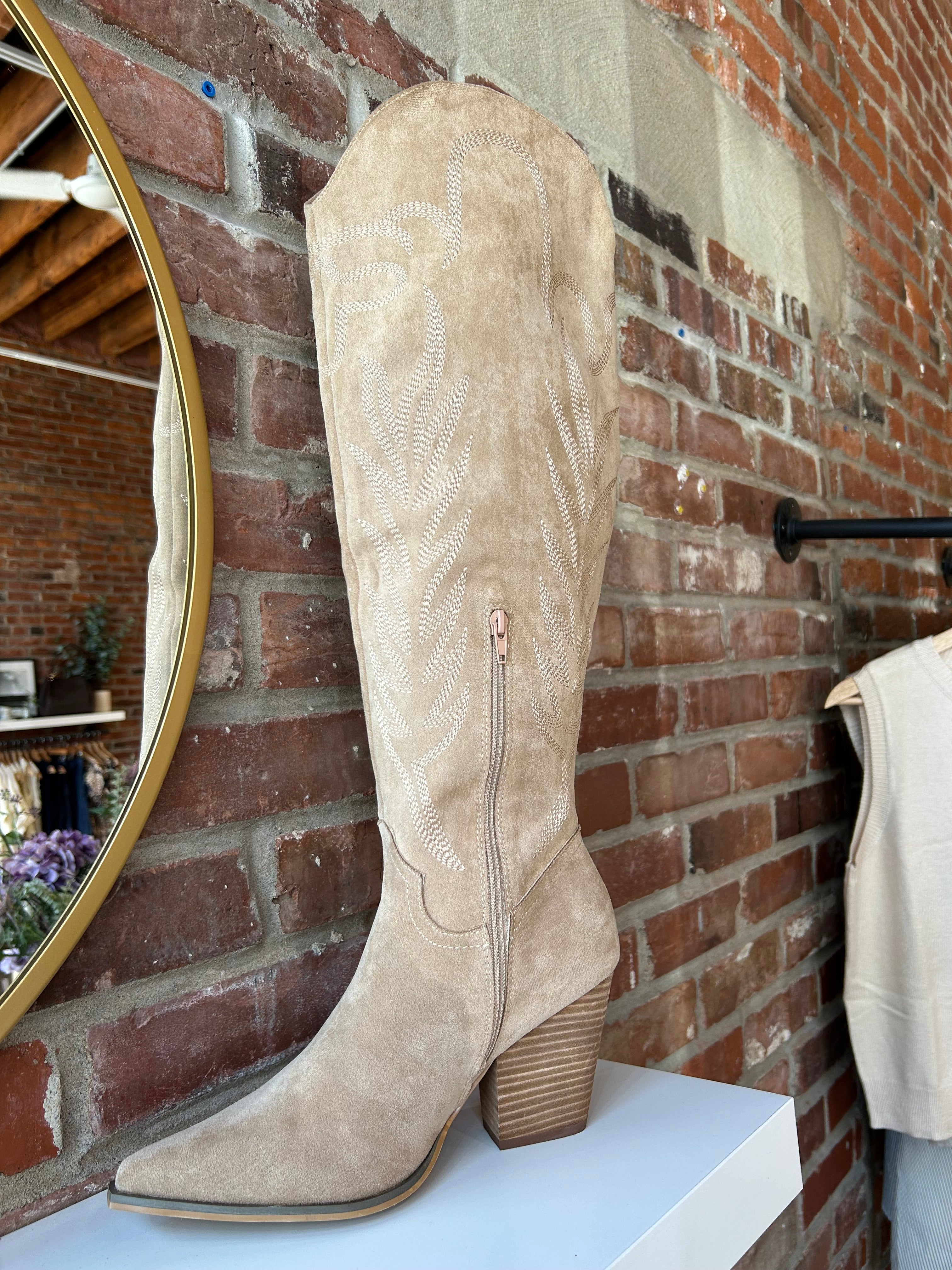Tan suede tall Western boot with embroidered stitching, pointed toe, and stacked block heel
