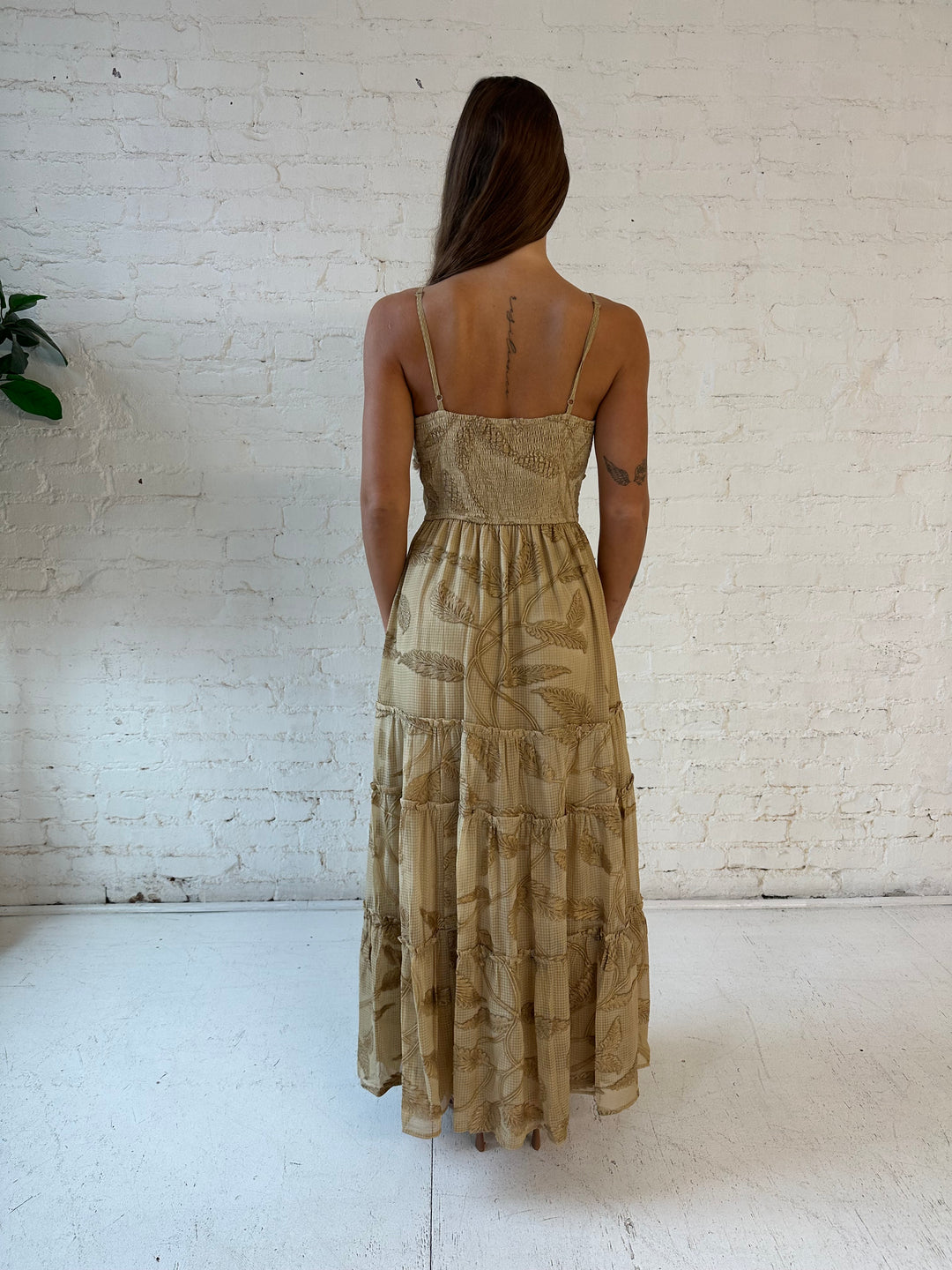 Woman wearing beige florall tiered maxi dress with gathered trim detail and smocked back. 