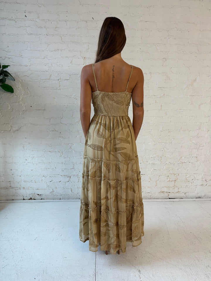 Woman wearing beige florall tiered maxi dress with gathered trim detail and smocked back. 