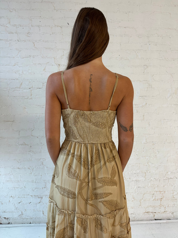 Woman wearing beige florall tiered maxi dress with gathered trim detail and smocked back. 
