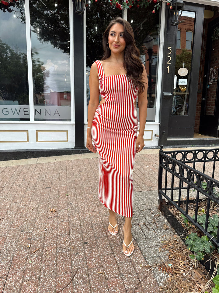 Woman wearing red and white striped textured midi dress with an open back. 