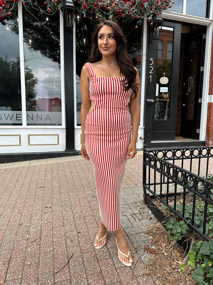 Woman wearing red and white striped textured midi dress with an open back. 