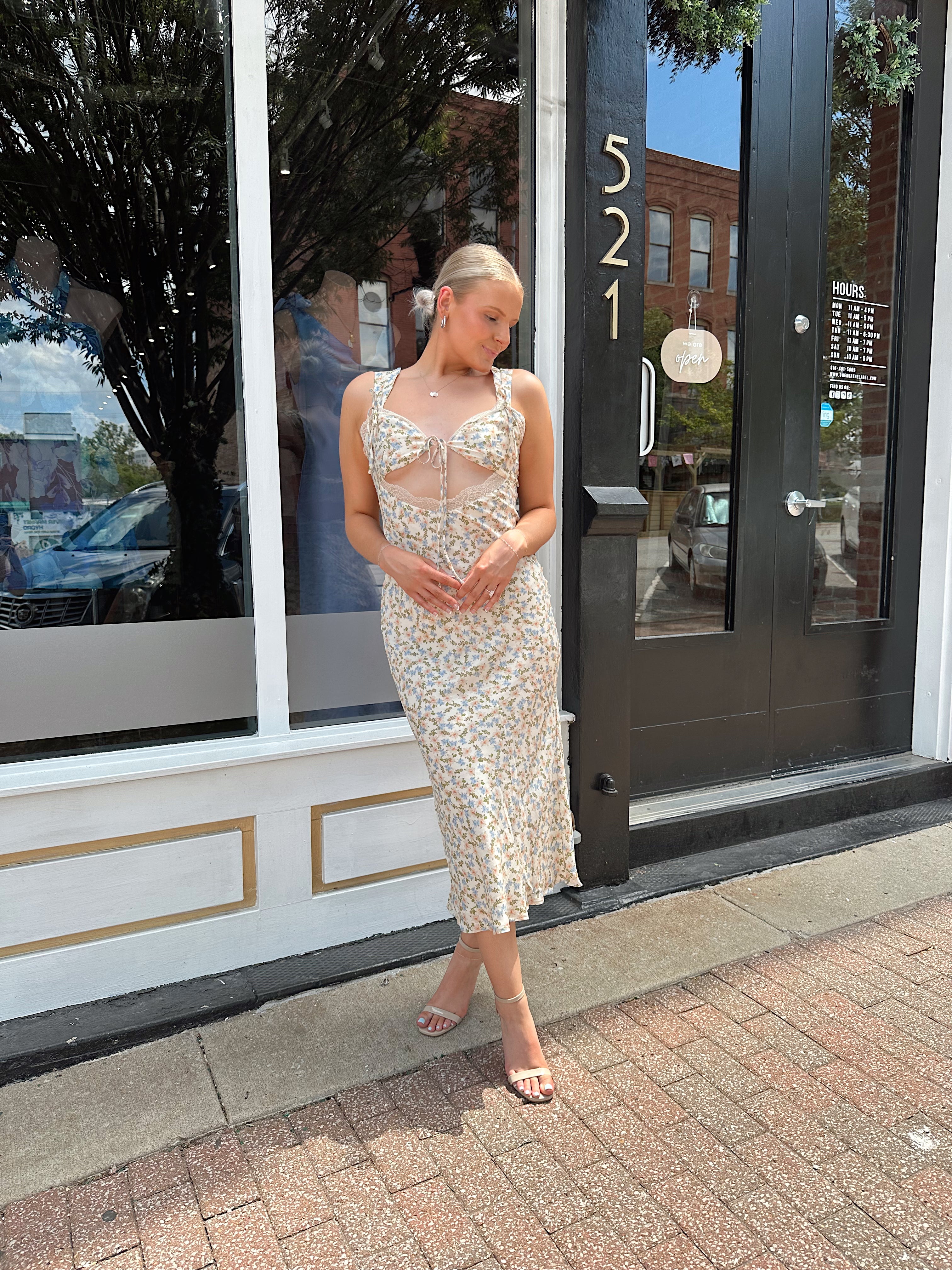 Beige floral satin midi dress with lace trim and cutout detail.