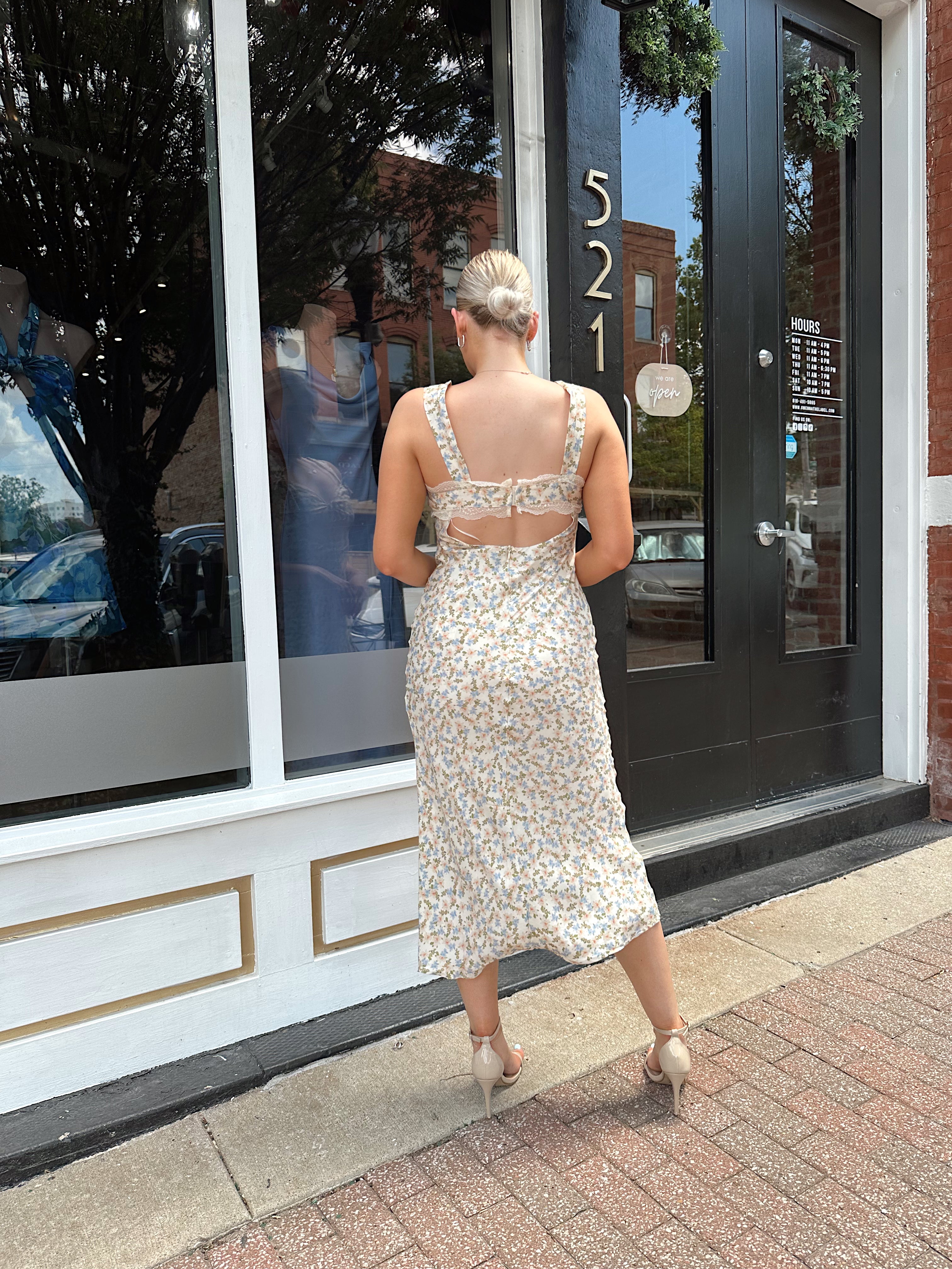 Beige floral satin midi dress with lace trim and cutout detail.