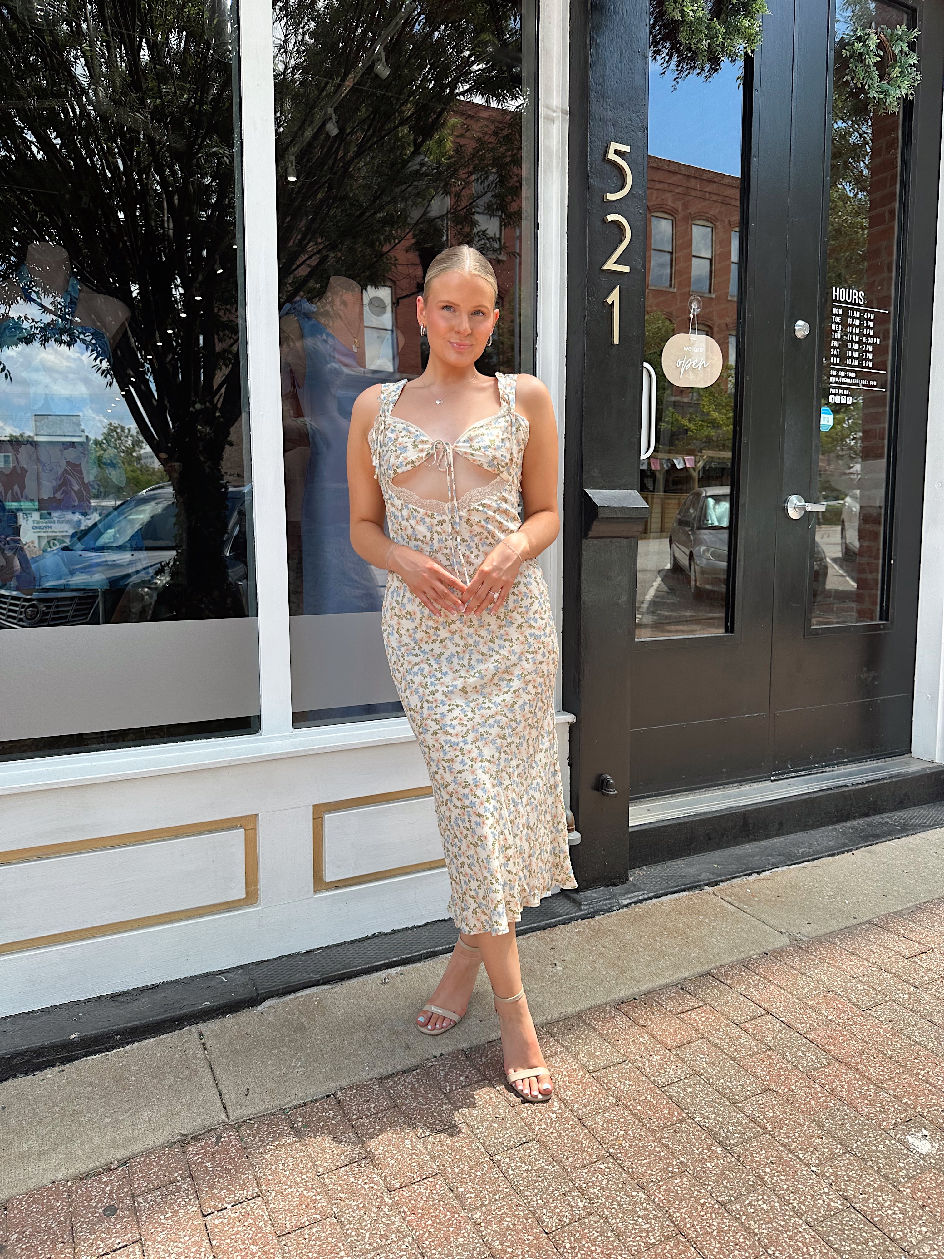 Beige floral satin midi dress with lace trim and cutout detail.