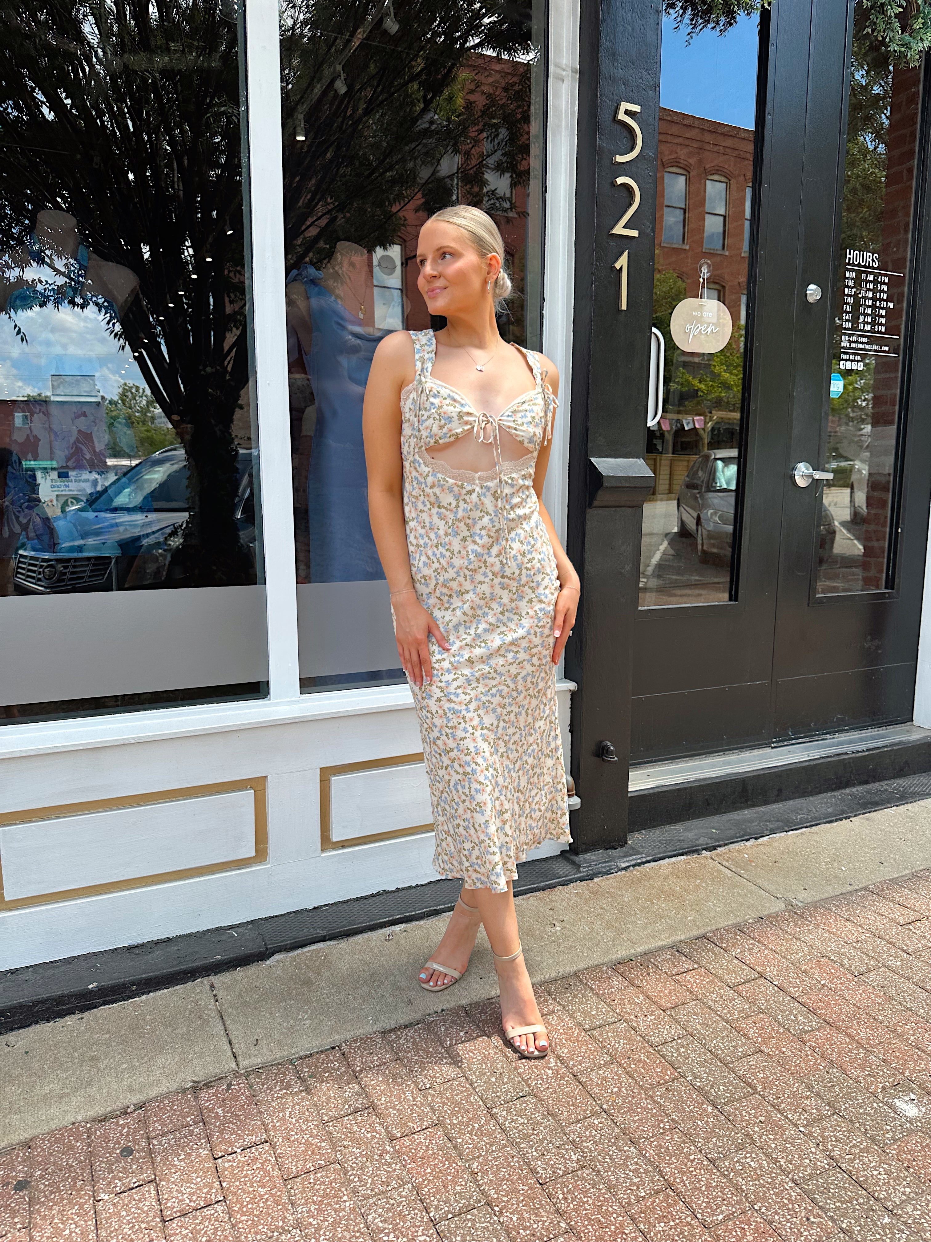 Beige floral satin midi dress with lace trim and cutout detail.
