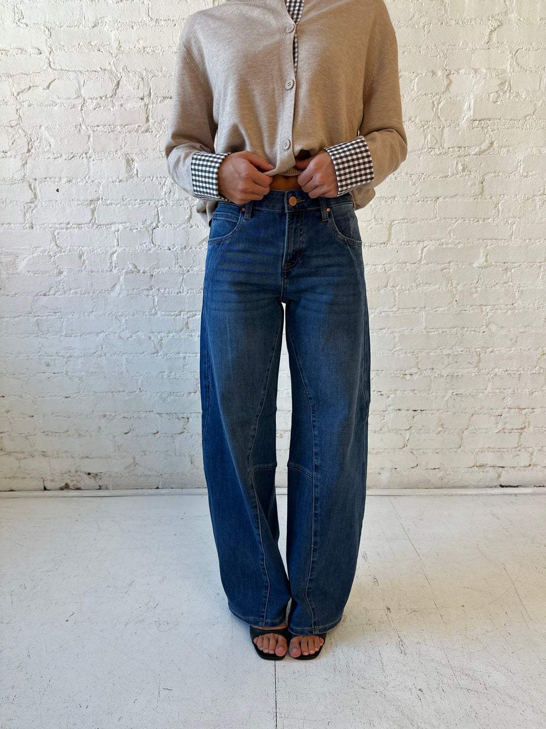 Woman wearing dark wash, slouchy barrel jean with sweater top. 