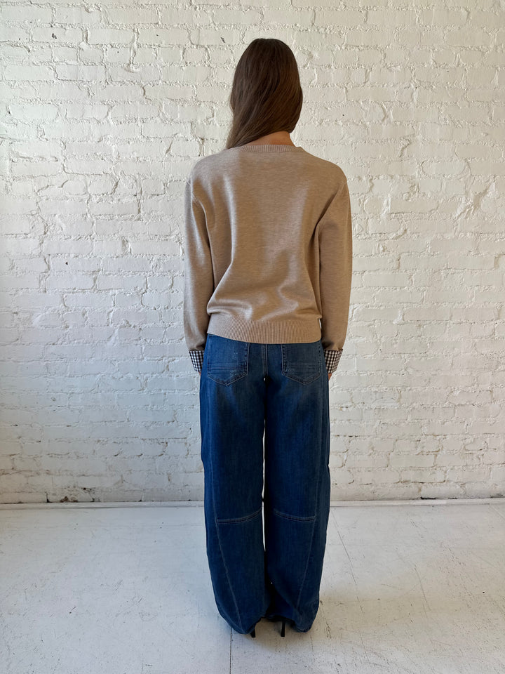 Woman wearing dark wash, slouchy barrel jean with sweater top. 