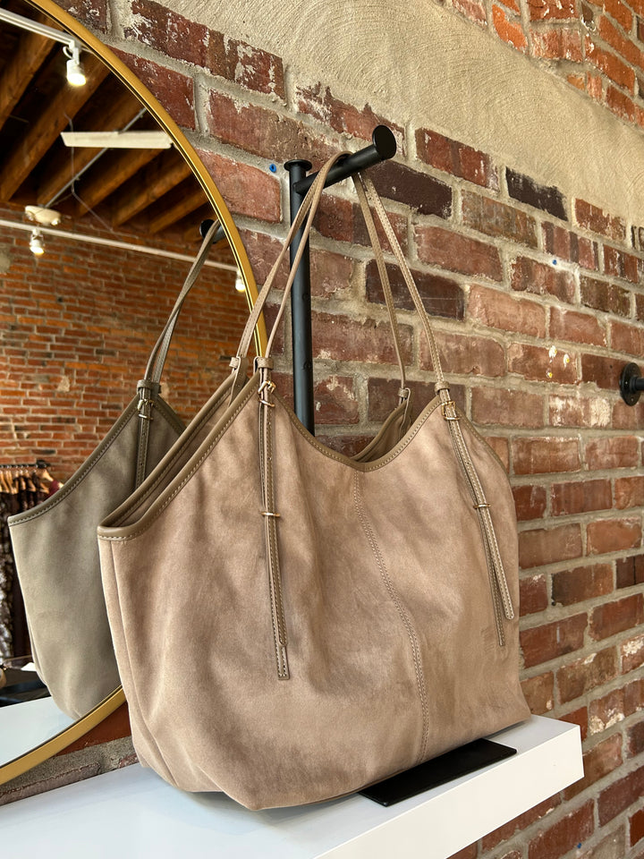 Beige suede oversized shoulder tote bag with adjustable shoulder straps. 