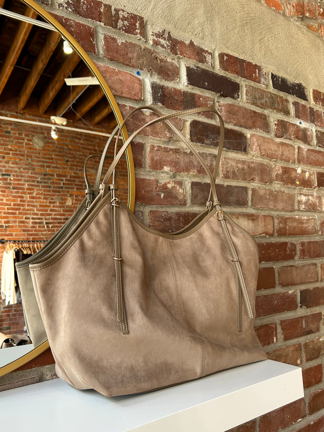 Beige suede oversized shoulder tote bag with adjustable shoulder straps. 