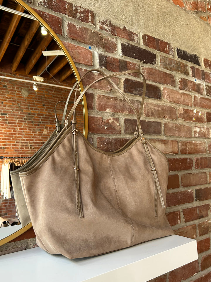 Beige suede oversized shoulder tote bag with adjustable shoulder straps. 
