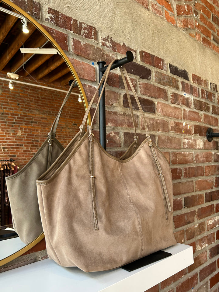 Beige suede oversized shoulder tote bag with adjustable shoulder straps. 