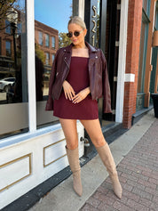 Woman wearing rose tailored mini dress with square neckline and front pockets.