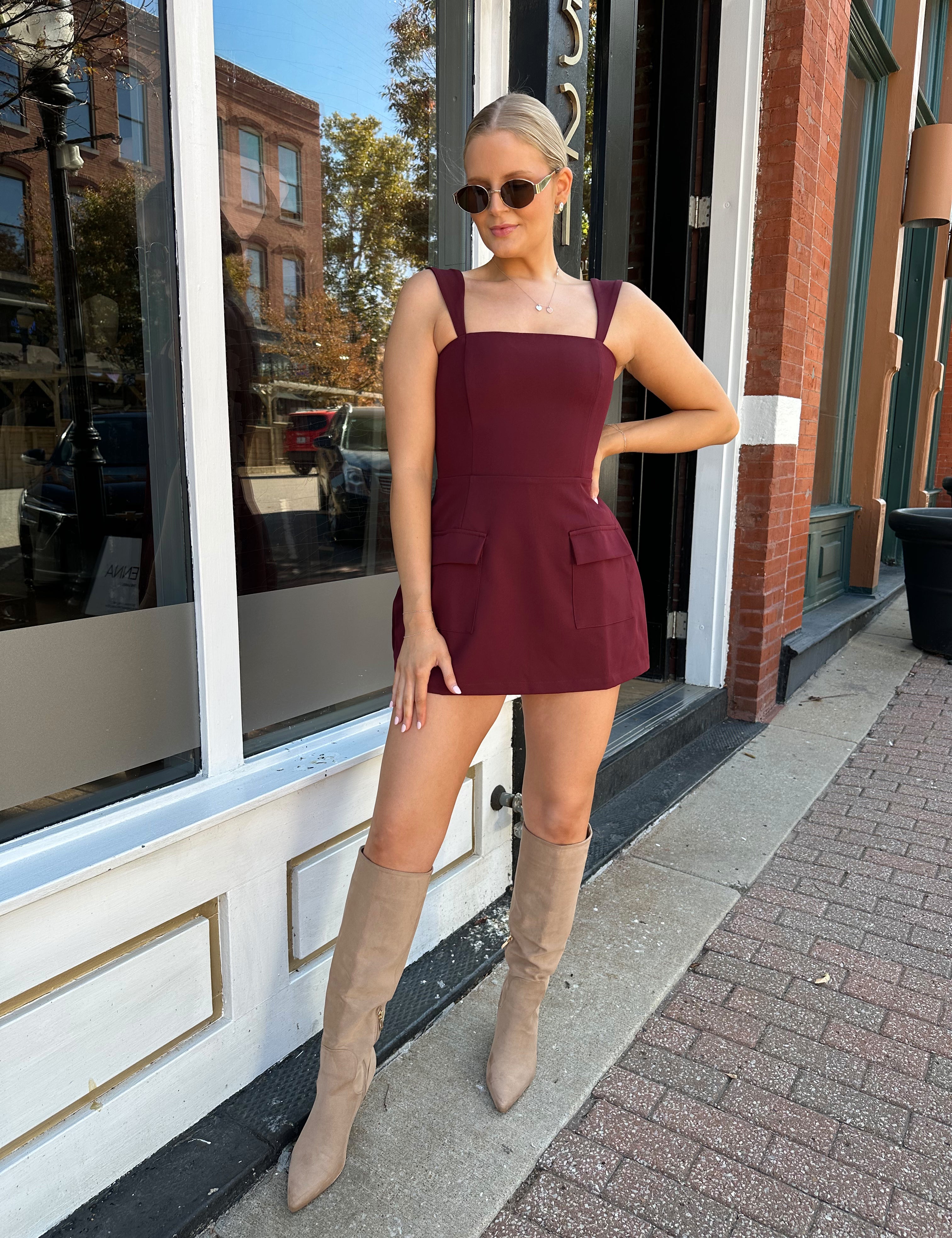 Woman wearing rose tailored mini dress with square neckline and front pockets.