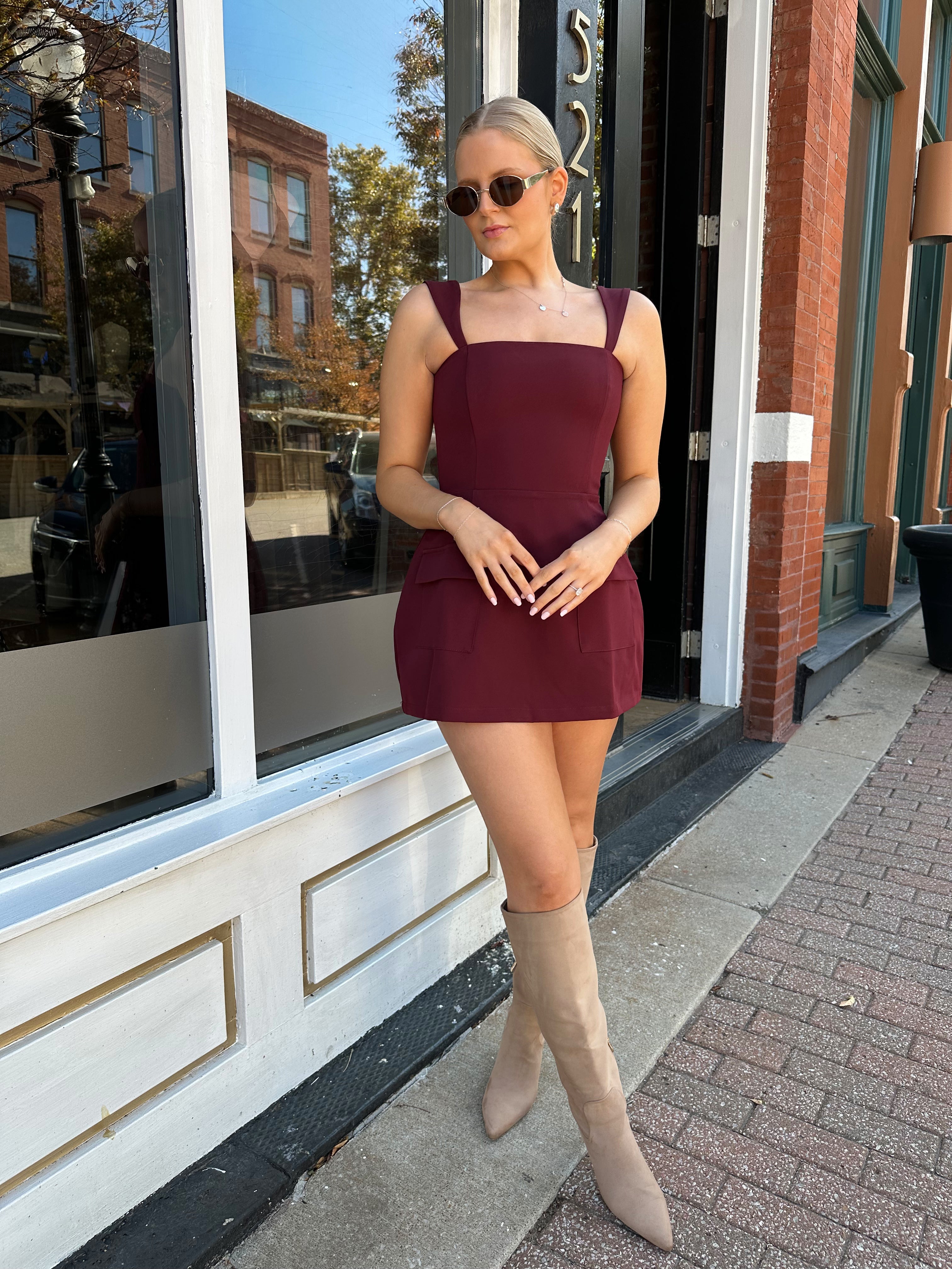 Woman wearing rose tailored mini dress with square neckline and front pockets.