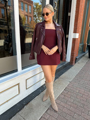 Woman wearing rose tailored mini dress with square neckline and front pockets. 