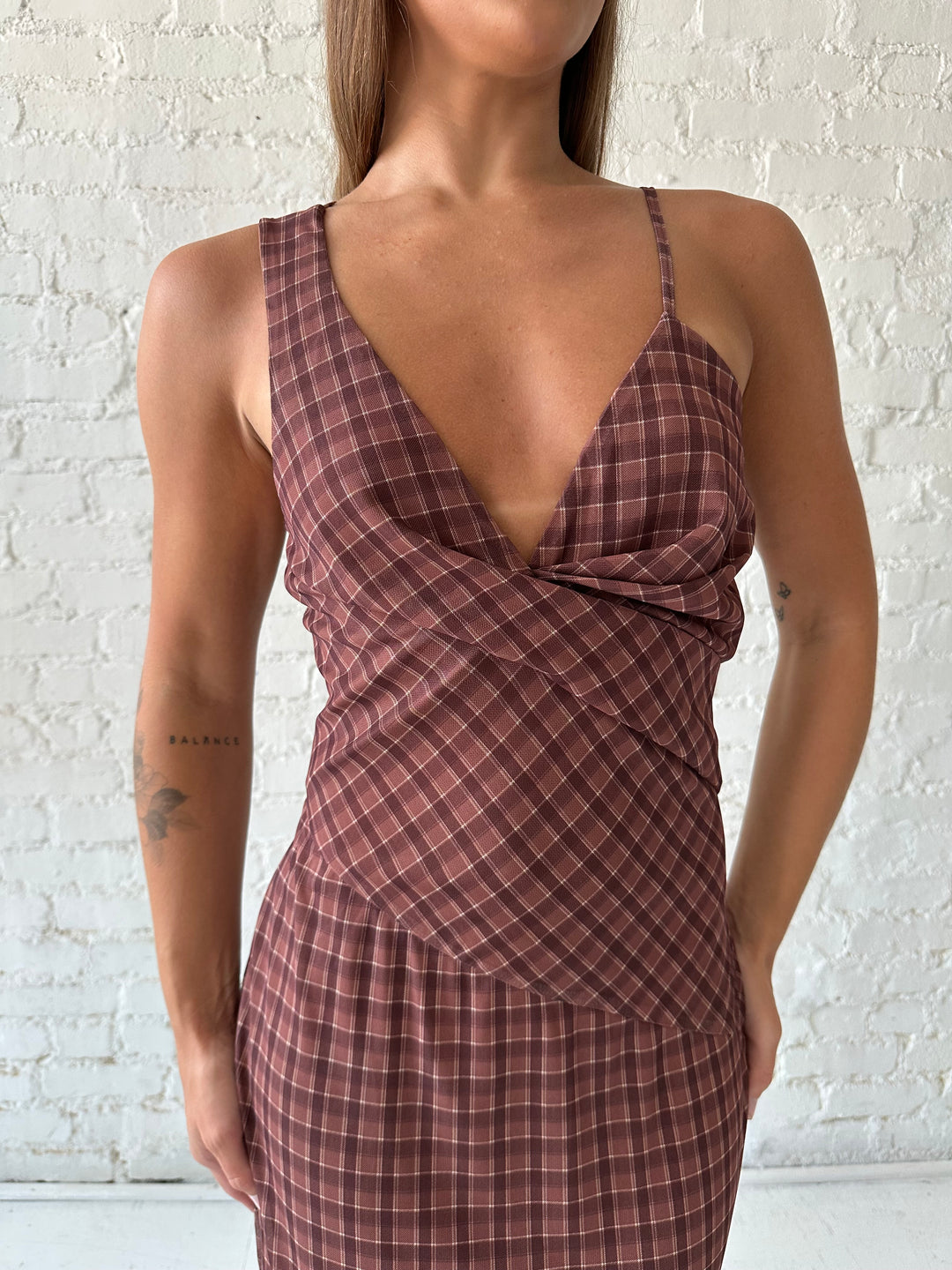Woman wearing brown plaid asymmetrical maxi dress.