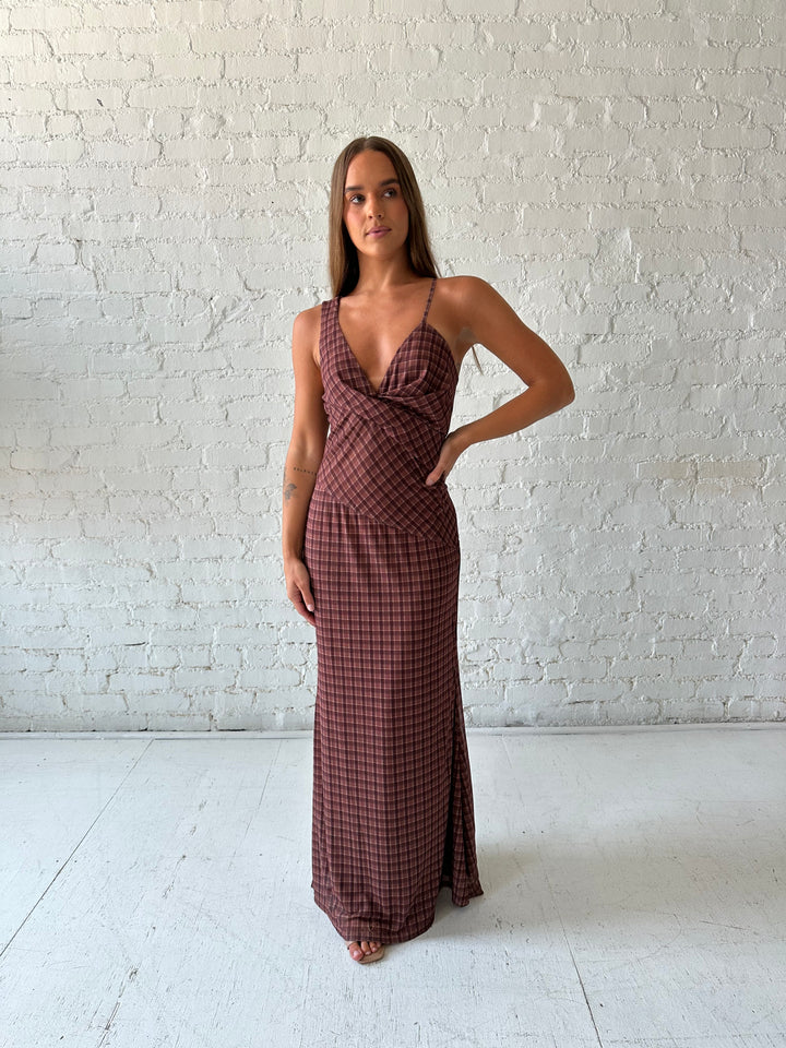 Woman wearing brown plaid asymmetrical maxi dress.