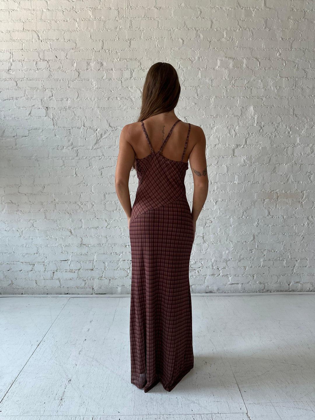 Woman wearing brown plaid asymmetrical maxi dress.
