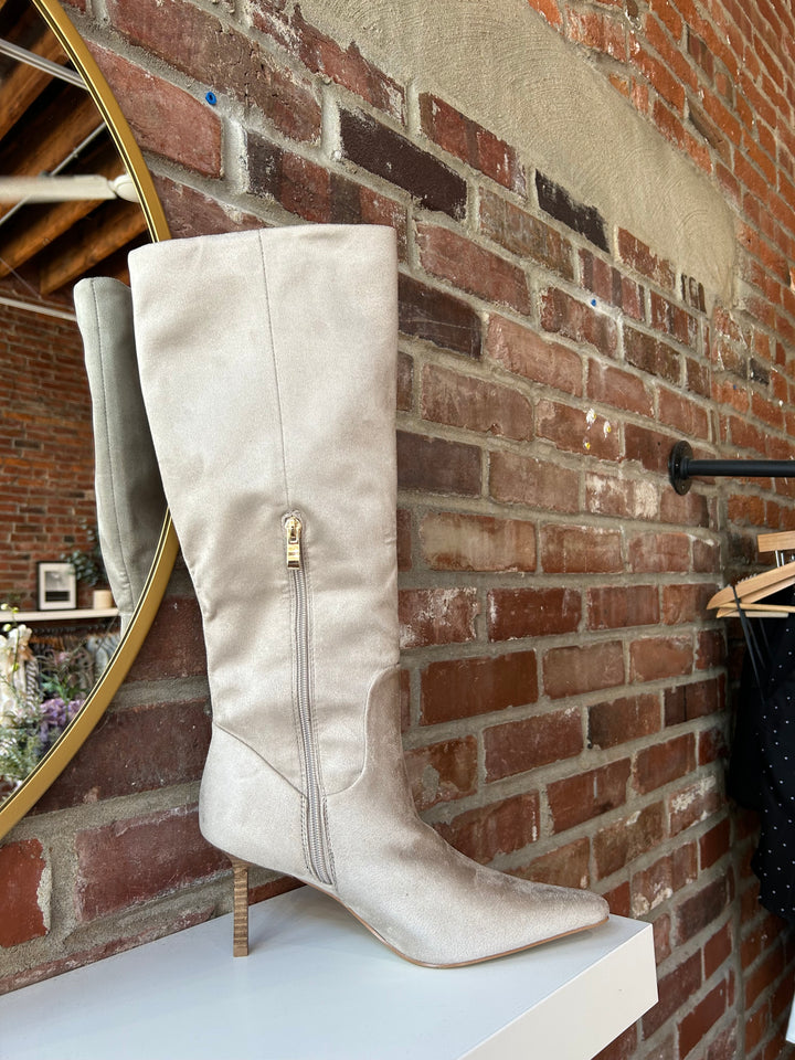 Oat colored suede tall knee boot with inner zip closure and stiletto heel.
