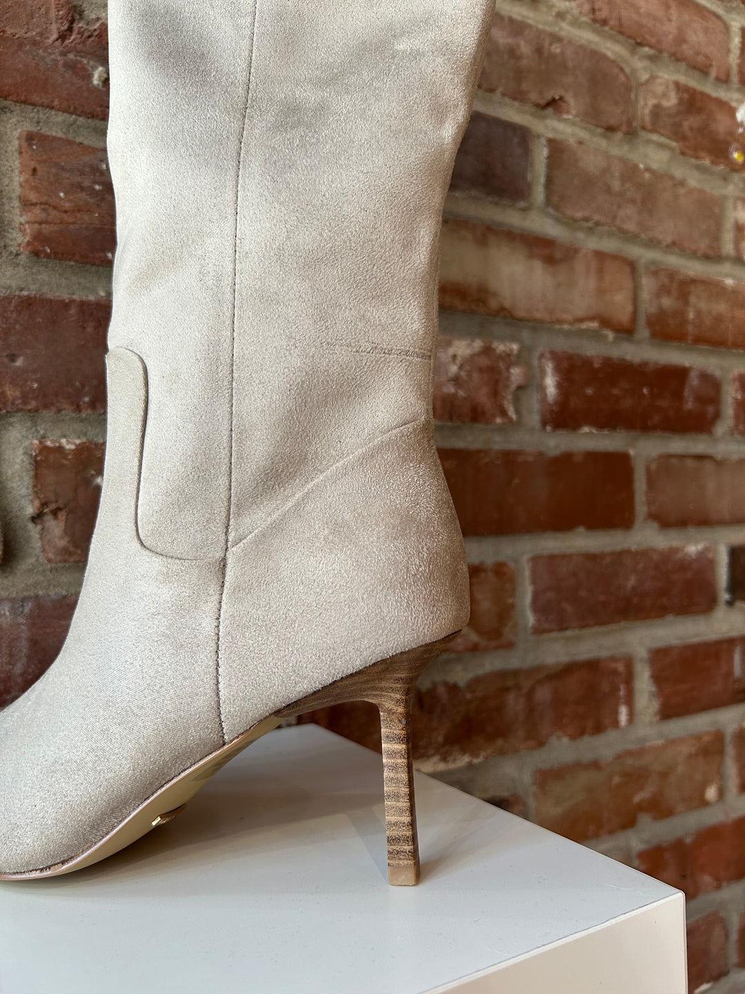 Oat colored suede tall knee boot with inner zip closure and stiletto heel.