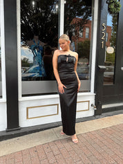 Black satin strapless midi dress with bow detail.