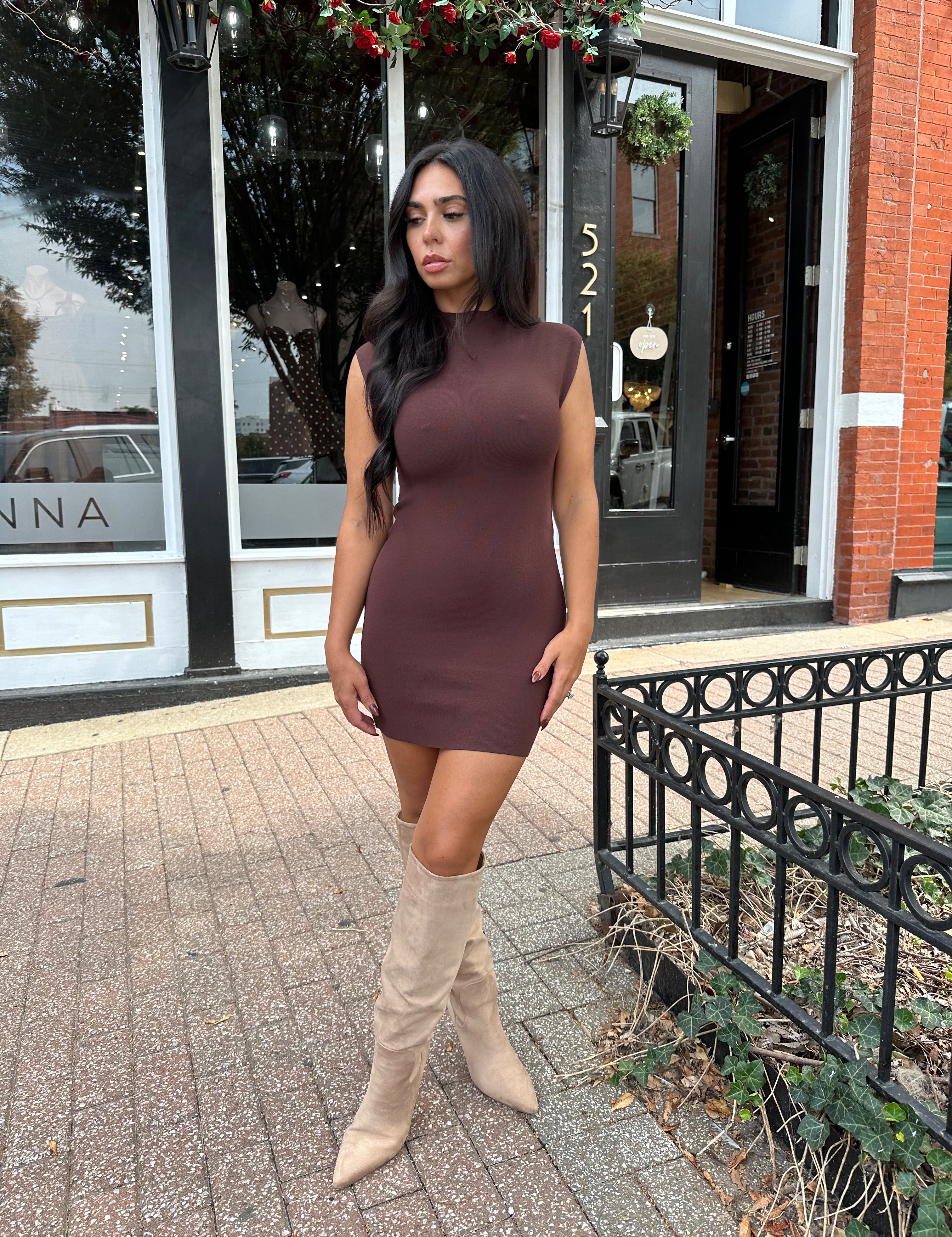 Woman wearing dark brown ribbed mock neck mini dress and suede knee boot.