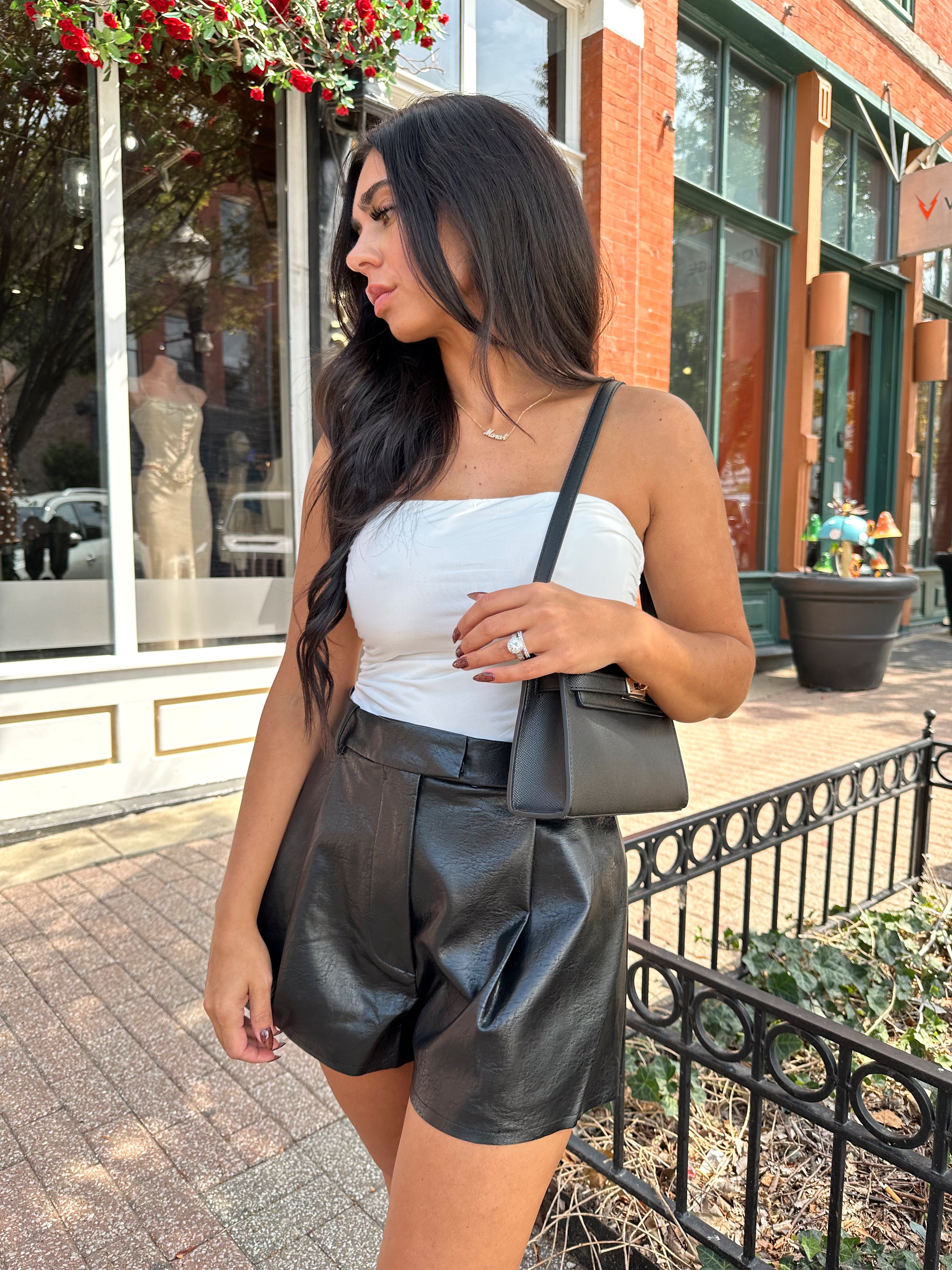 Woman wearing ivory ruched strapless tube top with slight shimmer.