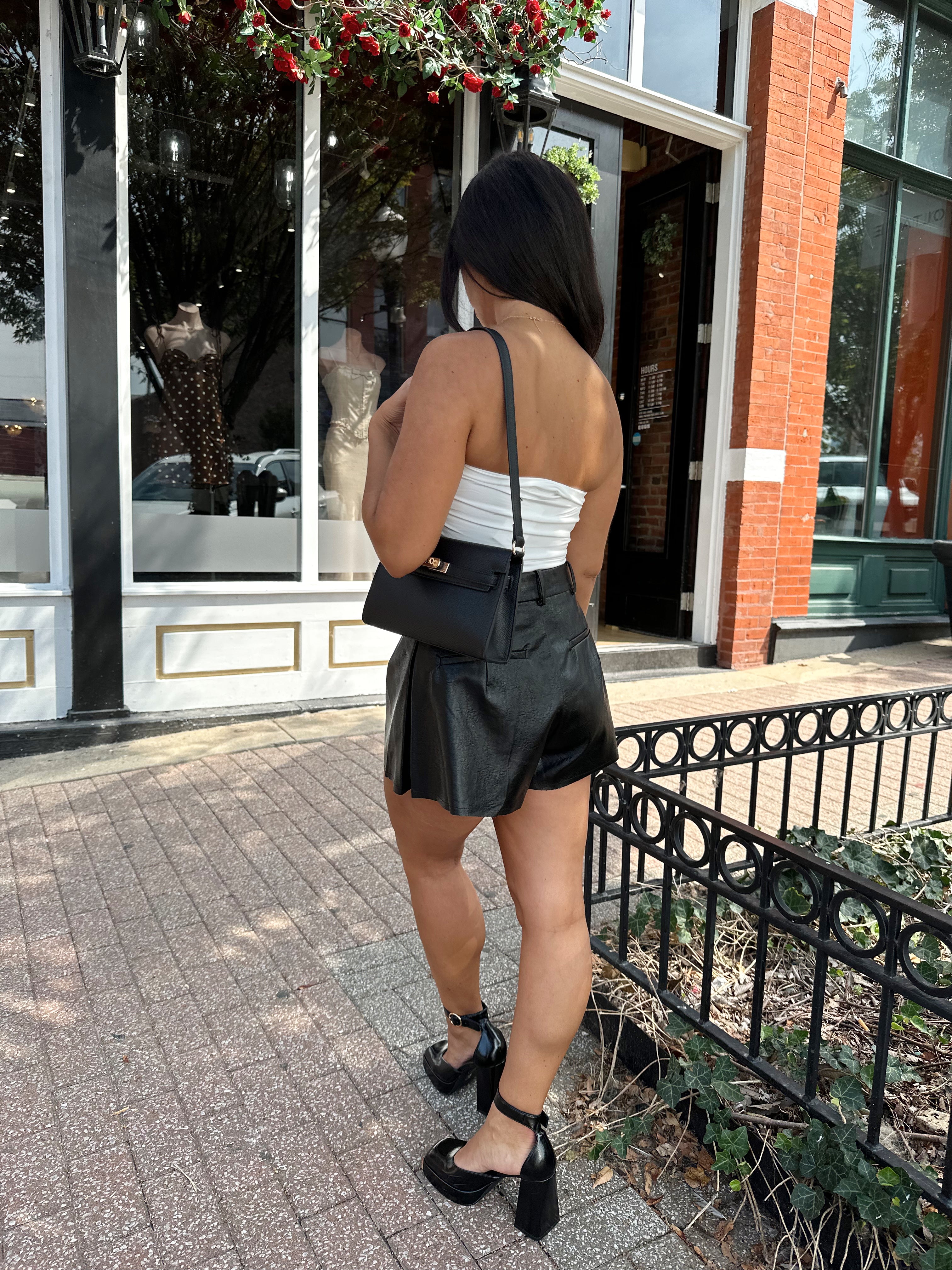 Woman wearing ivory ruched strapless tube top with slight shimmer.