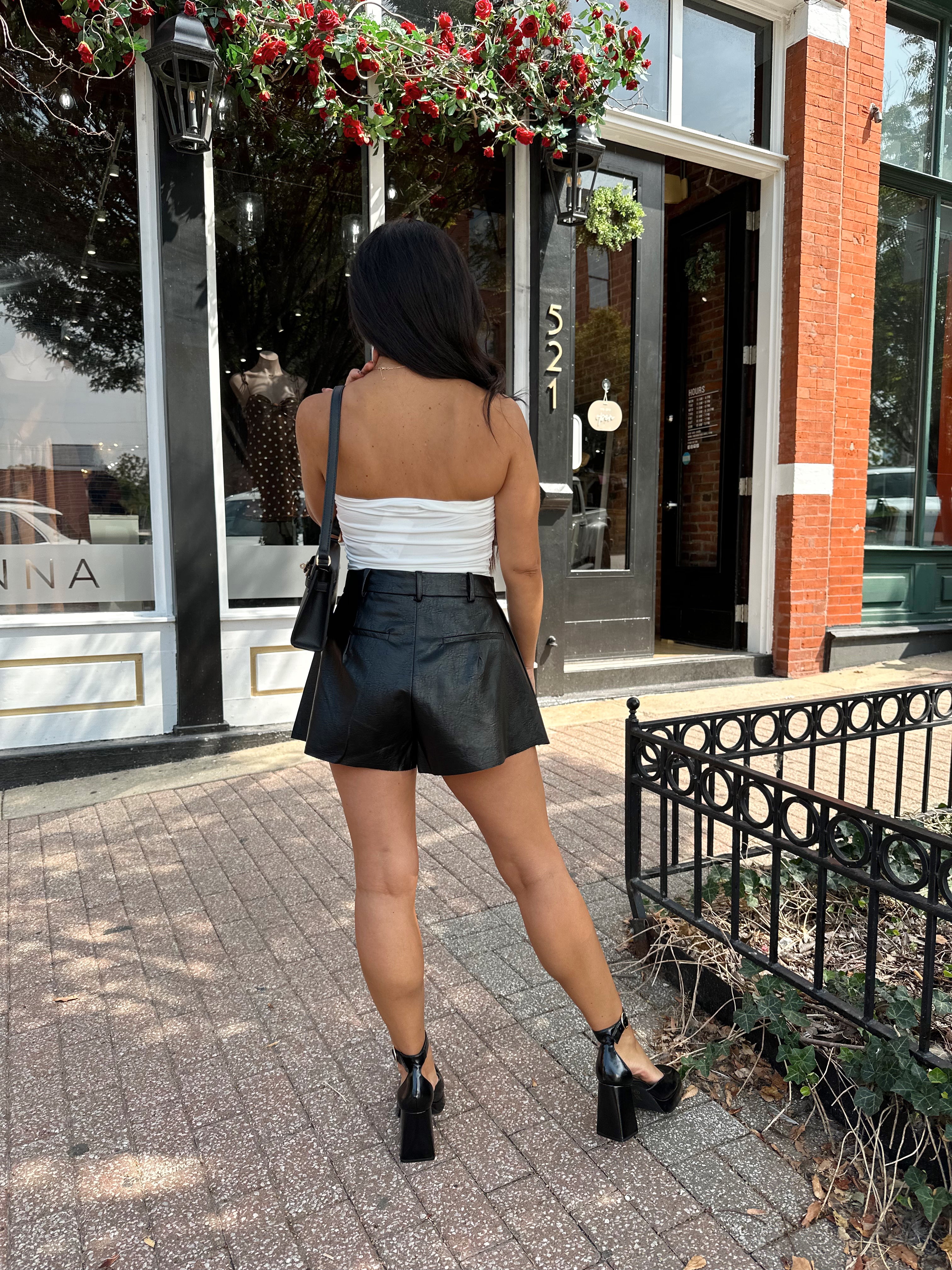 Woman wearing ivory ruched strapless tube top with slight shimmer.