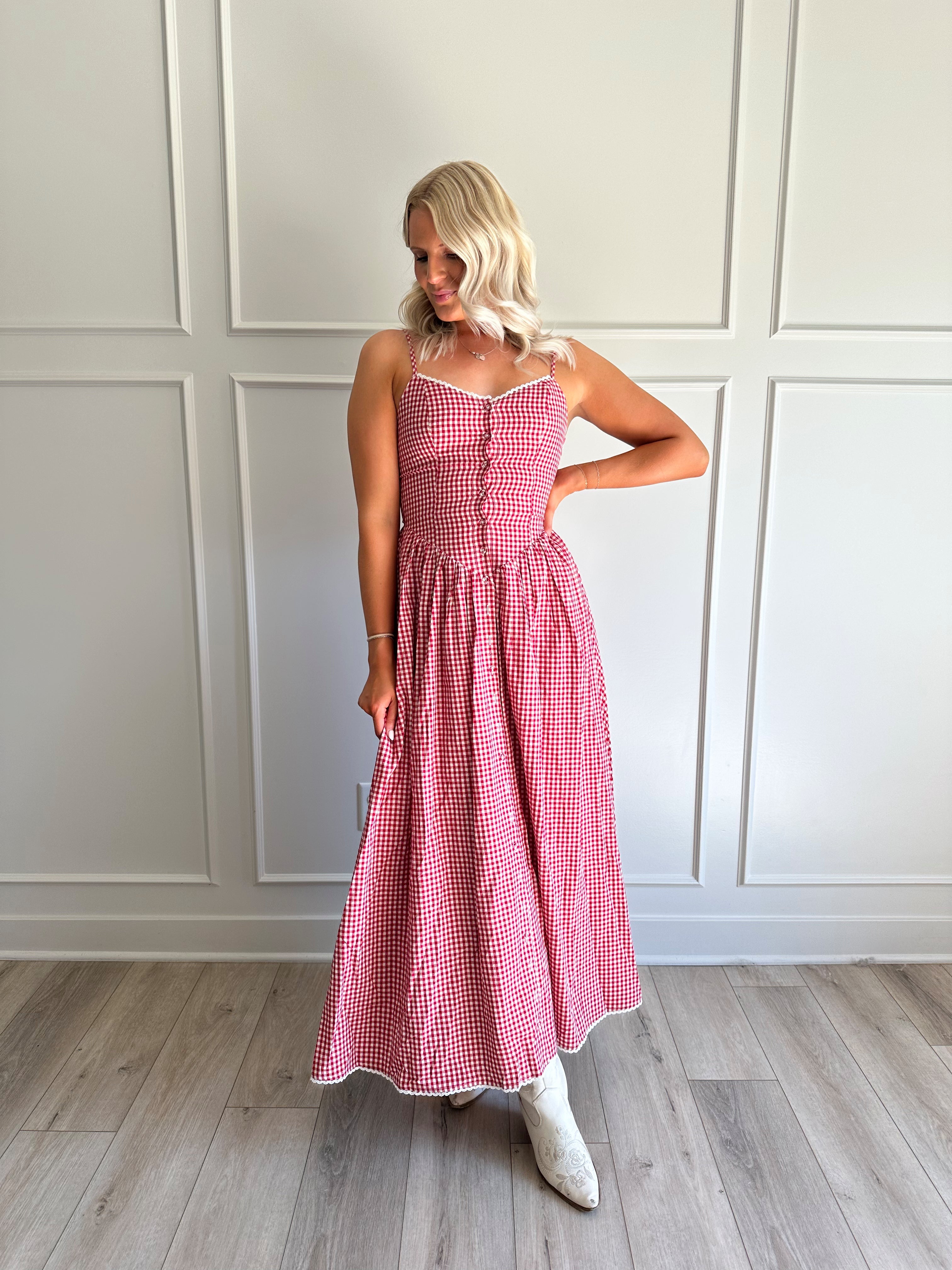 Woman wearing red gingham maxi dress with button detailing. 