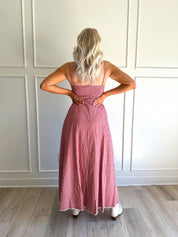 Woman wearing red gingham maxi dress with button detailing. 