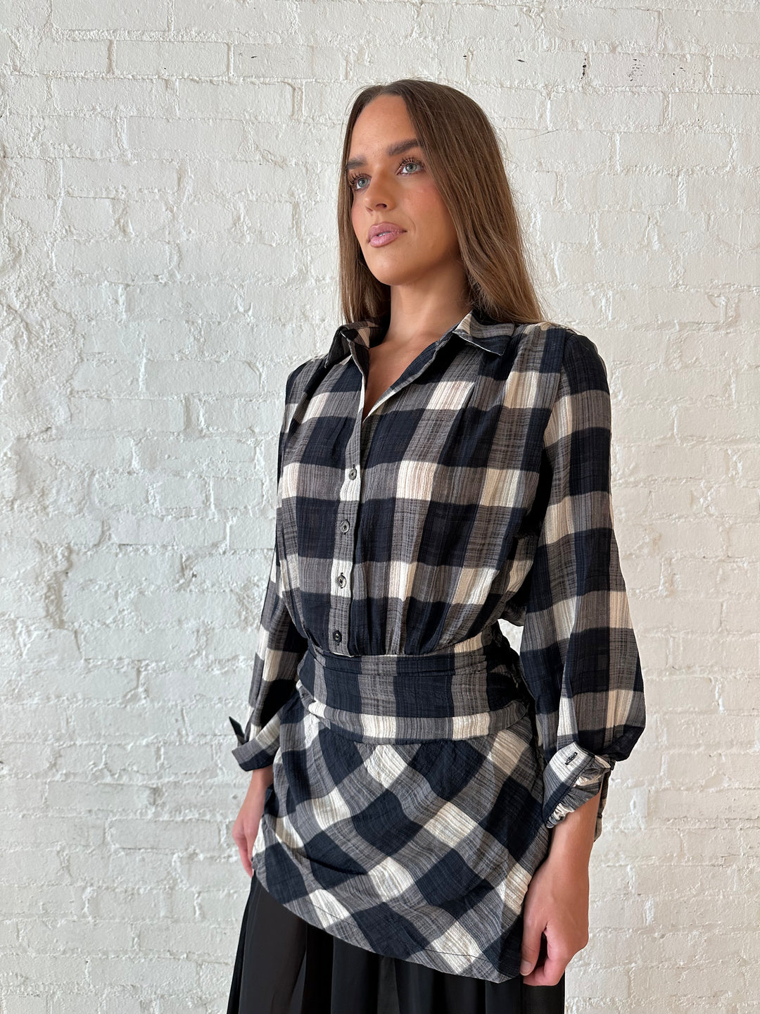 Woman wearing black checkered maxi dress with sheer maxi skirt bottom.